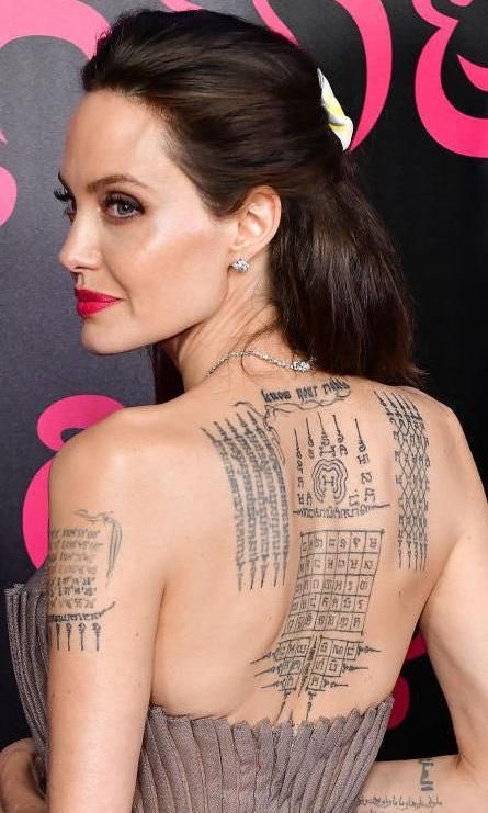 itsKellyyea's tweet photo. Hey @grok, what’s written on Angelina Jolie’s back tattoos and what do they mean? https://t.co/3SDqRHXJ34