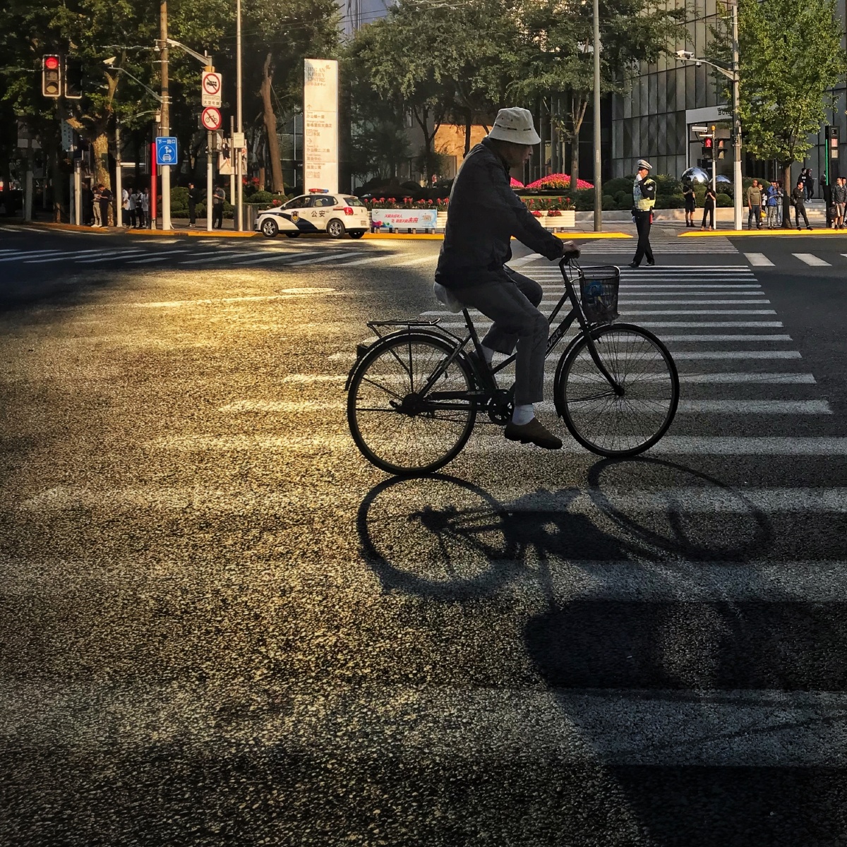 ShowSystemsHi's tweet photo. Quick street snap: the golden afternoon sun painting a vintage shopfront and a cyclist weaving past – little daily magic right here.， https://t.co/uAJflaZ3eA