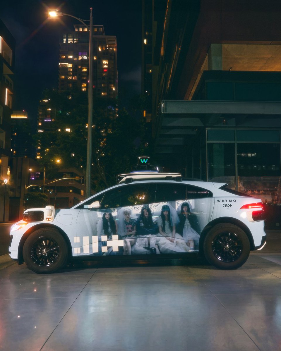 Waymo's tweet photo. Got your back ✨ @ILLIT_Official x Waymo car wraps are now driving in LA. https://t.co/mXxoq6CSCK
