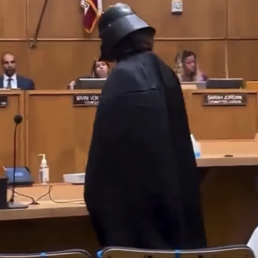 interesting_aIl's tweet photo. A man dressed as Darth Vader sarcastically “defends” Flock cameras at a San Diego city council meeting

“…Flock cameras are not only following the license plate readers… they are following children in parks and gymnasiums, and we need this” https://t.co/xoIIHzFQOx
