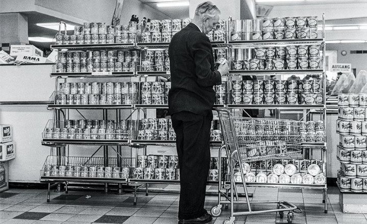narachronicle's tweet photo. Sekarang kita dorong shopping cart keliling supermarket tanpa mikir apa-apa.

Tahun 1937, orang malah malu memakainya.

Sylvan Goldman memperkenalkan shopping cart pertama di toko kelontong Humpty Dumpty, Oklahoma City, pada 4 Juni 1937.

Bentuknya juga nggak seperti cart yang kita kenal sekarang.

Dasarnya cuma dua kursi lipat yang dipasang saling membelakangi, diberi roda, lalu ditambahkan keranjang.

Masalahnya bukan desain.

Masalahnya manusia.

Sebagian perempuan sudah capek mendorong stroller, jadi nggak tertarik dengan benda yang kelihatannya mirip.

Sebagian laki-laki malah menganggap mendorong cart terlalu feminin.

Akhirnya Goldman menemukan solusi yang sangat... manusiawi.

Dia menyewa orang untuk pura-pura berbelanja sambil menggunakan cart tersebut.

Ada pria dan perempuan yang berkeliling toko dengan cart, memasukkan barang ke dalamnya, seolah benda itu sudah biasa dipakai semua orang.

Pelan-pelan pelanggan ikut mencoba.

Dan berhasil.

Shopping cart kemudian mengubah cara orang berbelanja. Keranjang yang tadinya cepat penuh sekarang bisa diganti dengan wadah beroda yang jauh lebih besar.

Yang lucu, teknologi ini sebenarnya sudah bekerja sejak awal.

Yang perlu diperbaiki justru persepsi manusianya.

Kadang sebuah penemuan nggak gagal karena desainnya buruk.

Cuma belum ada yang berani terlihat sebagai orang pertama yang menggunakannya.