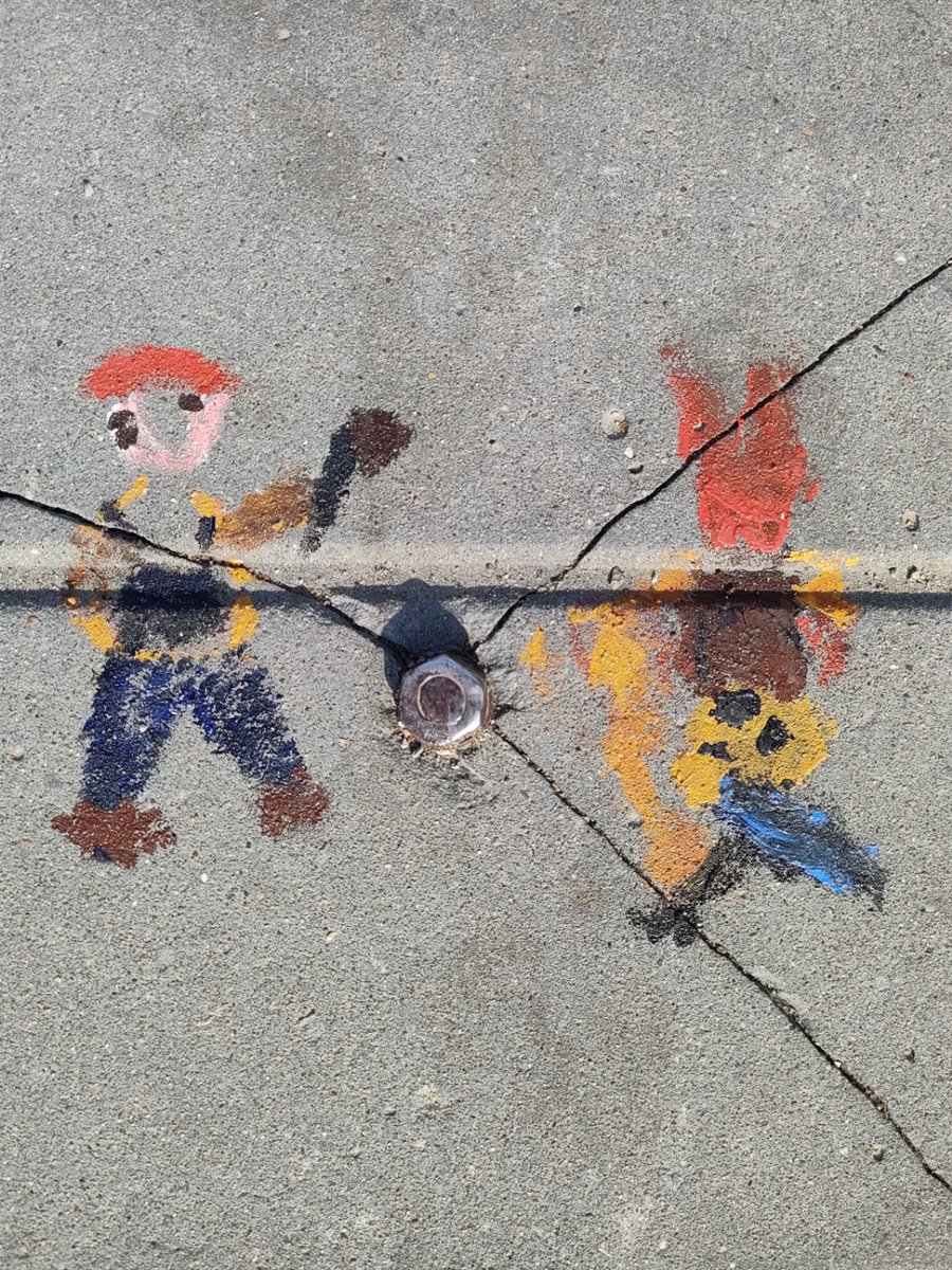 narmila_rajan's tweet photo. Spontaneous street snap of a street artist doodling with vivid chalk on the gray sidewalk, passersby stopping to glance at the tiny colorful scene right by the crosswalk.， https://t.co/7qtgDzEyv6