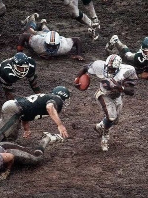 historyinmemes's tweet photo. Before AstroTurf, domed stadiums, and modern drainage systems, rain could transform an NFL field into a muddy battlefield, making games look more like trench warfare than football.

When rain entered the equation, football fields could become nearly impossible to play on. Cleats were sometimes taped to players’ feet to prevent slipping, while gaining even a few yards became a monumental challenge.

Mud was the great equalizer. Speed and finesse meant little when players could barely find their footing. Games became tests of pure mental and physical toughness, with some teams even choosing not to cover their fields during rain when facing more talented opponents, hoping to win through endurance instead.

It’s a rare sight in the NFL today, where games can be paused when standing water creates unsafe conditions. Muddy fields are now a relic of football’s past, along with the rugged mindset of the era in which the game was played.