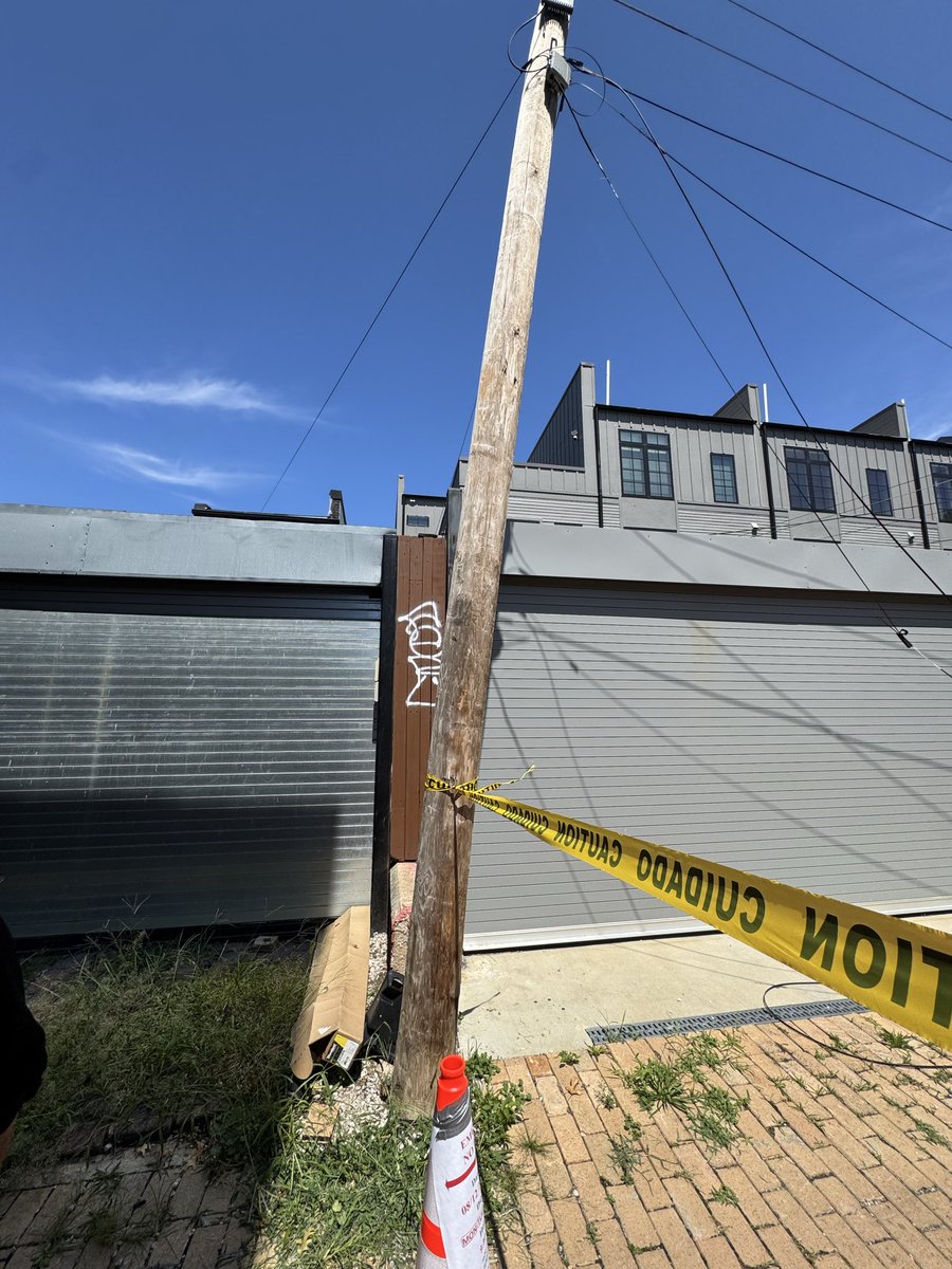 DCskroot's tweet photo. At 10:44am today @DC_DOB had a trash truck in the alley between R st nw and Warner St NW and took out a telephone pole. They didn’t report it and left a pole with live wires hanging in the alley. Thanks to residents the alley is now closed but still dangerous @PoPville https://t.co/eerWGuH3BV