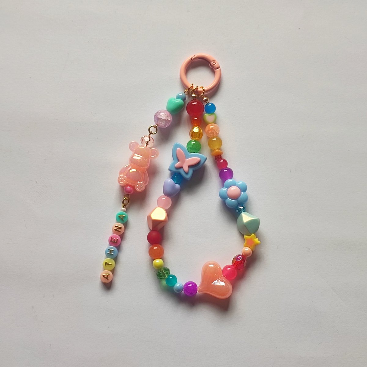 TheFunPart_'s tweet photo. Custom-named bag charms are becoming a hit again—&amp; we totally get why! This colorful cutie was made w/ playful beads, a sweet little teddy, butterflies, flowers,&amp; lots of happy colors, all personalized with Athena’s name. 
Message us to customize yours! 

#charms #bagcharm https://t.co/hKHtmvaIJJ