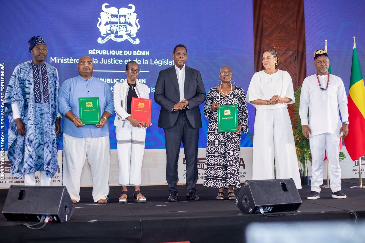 LNTribune's tweet photo. #Bénin : trois Afrodescendants obtiennent la nationalité lors de la #JISTNA2026 à #Ouidah
Trois Afrodescendants ont reçu leur attestation de nationalité béninoise à Ouidah, ce dimanche 23 août 2026, dans le cadre de l’édition 2026 de la Journée internationale du souvenir de la traite négrière et de son abolition (JISTNA). La remise s’est déroulée lors d’une cérémonie conduite par le ministère de la Justice et de la Législation, sous le thème « De la Porte du Non-Retour à la Porte du Retour ». La cérémonie de remise des attestations a réuni le ministre de la Justice et de la Législation, #YvonDétchénou, ainsi que la ministre des Affaires étrangères chargée de l’Intégration des Afrodescendants, Corinne Amori Brunet. Lors de l’ouverture officielle de l’événement, la ministre #AmoriBrunet a insisté sur la nécessité de faire de la mémoire le point de départ d’un lien renouvelé avec les Afrodescendants. Il s’agit de la première fois qu’une remise d’attestations de nationalité est organisée dans le cadre spécifique de la JISTNA, donnant à cet événement mémoriel une portée juridique et citoyenne inédite.