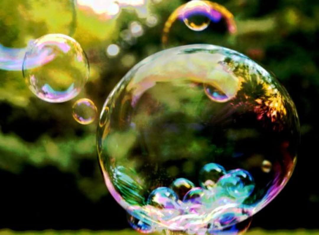 I_Tachion's tweet photo. A bubble is a globule of one substance inside another, usually gas in a liquid. Due to the Marangoni effect, the bubbles can remain intact once they reach the surface of the substance.

Frequently, when we carry out various activities, we produce bubbles. Bubbles are formed because air or steam is enclosed within a liquid and this is achieved, for example, by shaking a mixture of soap with water.

If we use a wire of any shape: triangular, square, hexagonal, round, spherical bubbles will always form. But why always spheres? The answer is given by the Law of Least Effort.

According to this law, processes in nature are carried out in such a way that there is always a minimum of some physical quantity. This minimum can be presented in energy, in distance, in quantity of movement, in time. For example, when you drop a marble placed on the edge of a saucepan with a round bottom, the marble will move from one side to the other, but eventually it will stop in the center, which is precisely the place where it has the least energy. Another example occurs when the water runs down a drain. As the water goes down, it forms a whirlpool, since in this way the air inside the tube can easily escape allowing the water to enter. In this case, the time the water drops is the minimum.

Thus, soap bubbles take a spherical shape because the spheres have the smallest surface area for the amount of air enclosed within the bubble, also minimizing the energy that this surface has.

 The drops of water that fall when it rains tend to form spheres, because by taking that shape their energy is minimized and the external surface of the drop is minimized. If we had the fortune to be on a satellite orbiting the Earth and therefore be with near zero gravity, then we would observe that the water droplets would float like spheres inside the spacecraft, in a similar way to how soap bubbles do. in the air.

This behavior has to do with the surface tension and cohesion force in a liquid.

 Surface tension is the force exerted on the surface of a liquid, similar to the force that stretches a blanket on a hoop. This tension is what allows some insects to walk on the surface of the water or that we can deposit a steely razor on the water, without the razor sinking despite its greater density.

 On the other hand, the cohesion force in a liquid is an attractive force between its molecules that tends to hold them together. For example, alcohol has a lower cohesion force between its molecules than water. For this reason, alcohol volatilizes faster than water.

 When a drop of water forms, both the cohesion force and the surface tension act. While the cohesive force holds the molecules of the liquid in the drop together, the surface tension causes it to take on a spherical shape, minimizing the surface area that encloses the drop.

 If we deposit drops of alcohol and oil on glass, we will notice that the drop of alcohol is crushed more than the drop of oil, because the cohesion force and the surface tension of the oil are greater than in alcohol.

 One application of this occurs when we wash clothes. It turns out that the surface tension of water decreases when mixed with detergent. This property is what allows better cleaning of clothes, because by reducing the surface tension of the water, it penetrates better into the fibers of the fabrics and the chemicals that these detergents contain act to remove the dirt from them and thus clean the clothes.