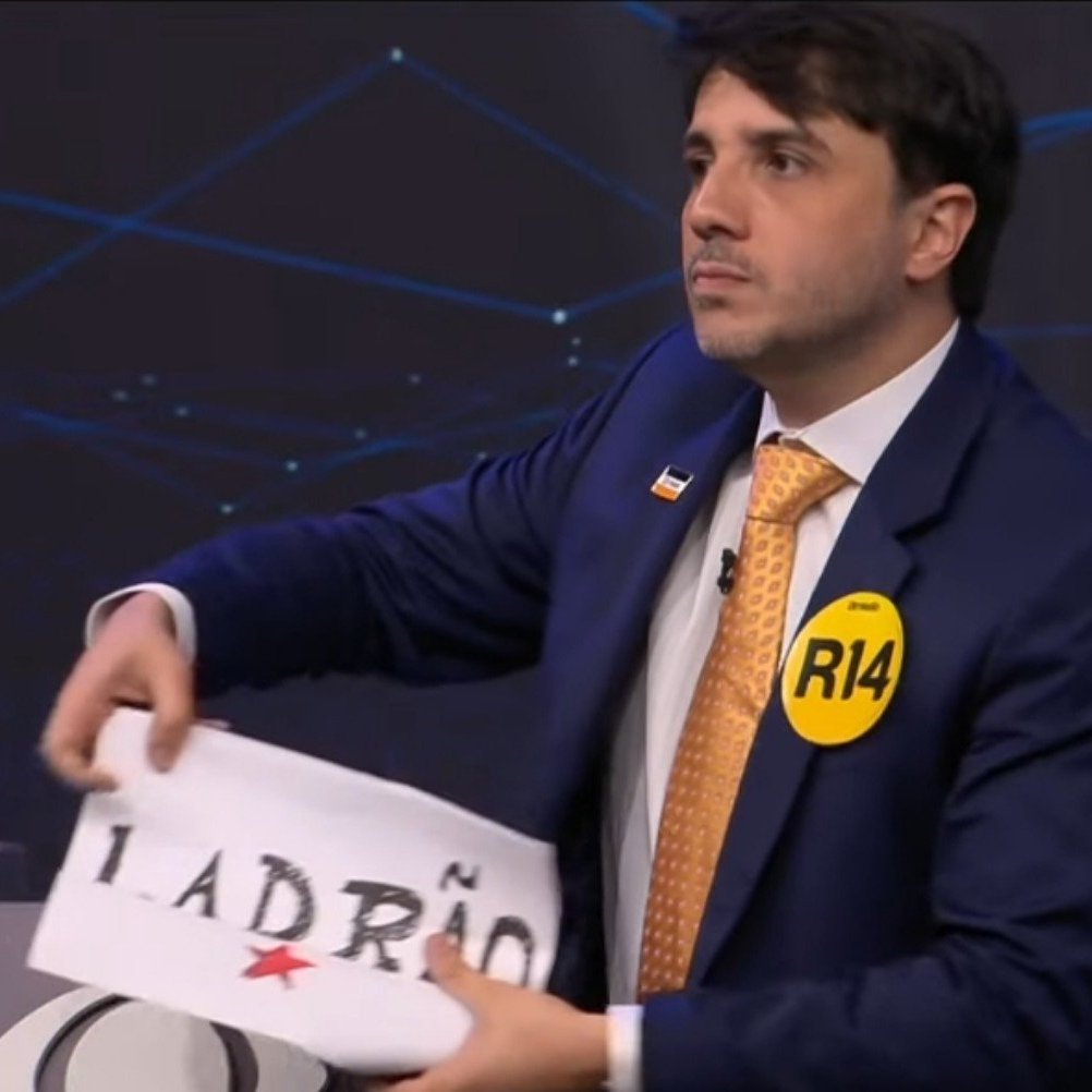 republiqueBRA's tweet photo. 🗣️ Em suas considerações finais no debate presidencial da Band, Renan Santos coloca uma placa com a palavra “Ladrão” no púlpito vazio de Lula. https://t.co/BejbGEzGKv