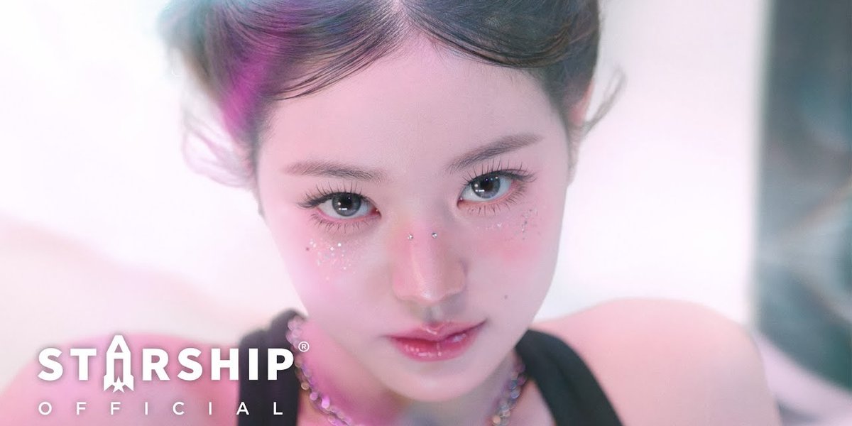 A close-up portrait of a young woman with pink makeup accents and glitter, with the "STARSHIP OFFICIAL" logo in the bottom left corner.