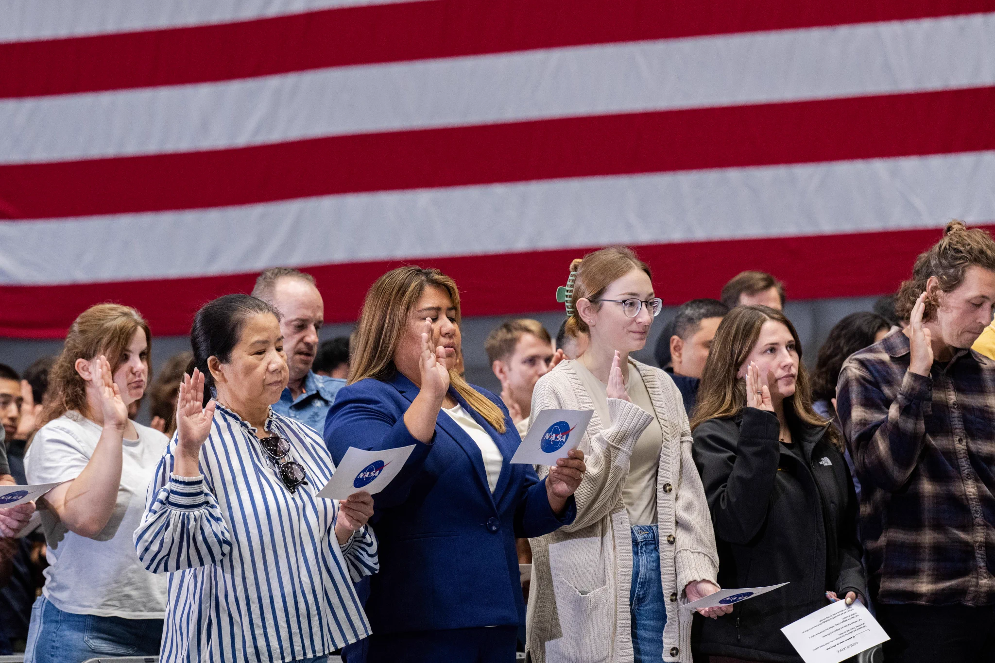 Participants stand while Associate Administrator Amit Kshatriya administers the Oath of Office during the NASA Civil Servant Swearing-in Ceremony in the National Full-Scale Aerodynamics Complex (NFAC) 80-by-120-foot test section, N221. Credit: NASA/Brandon Torres Navarrate