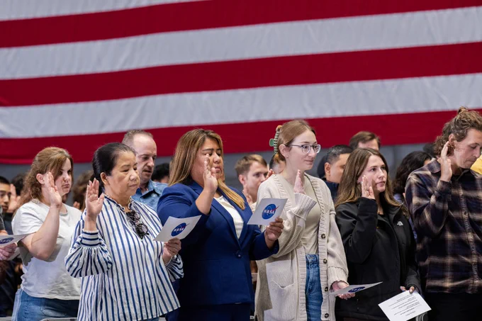 Participants stand while Associate Administrator Amit Kshatriya administers the Oath of Office during the NASA Civil Servant Swearing-in Ceremony in the National Full-Scale Aerodynamics Complex (NFAC) 80-by-120-foot test section, N221. Credit: NASA/Brandon Torres Navarrate