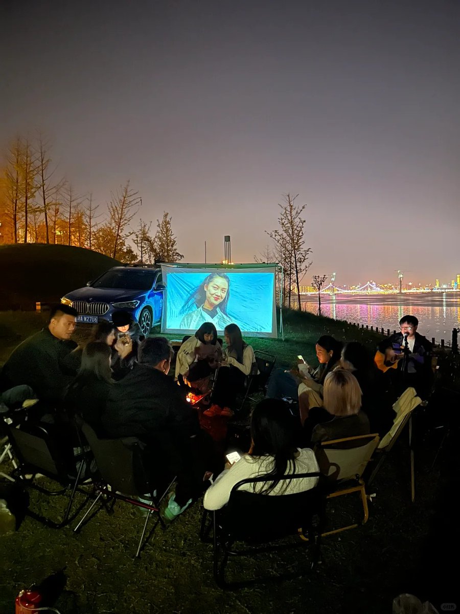 whitetiann's tweet photo. 晚上和朋友河边支起屏幕看电影，有人弹吉他，灯光倒影超治愈 https://t.co/E9dcwdGuGD