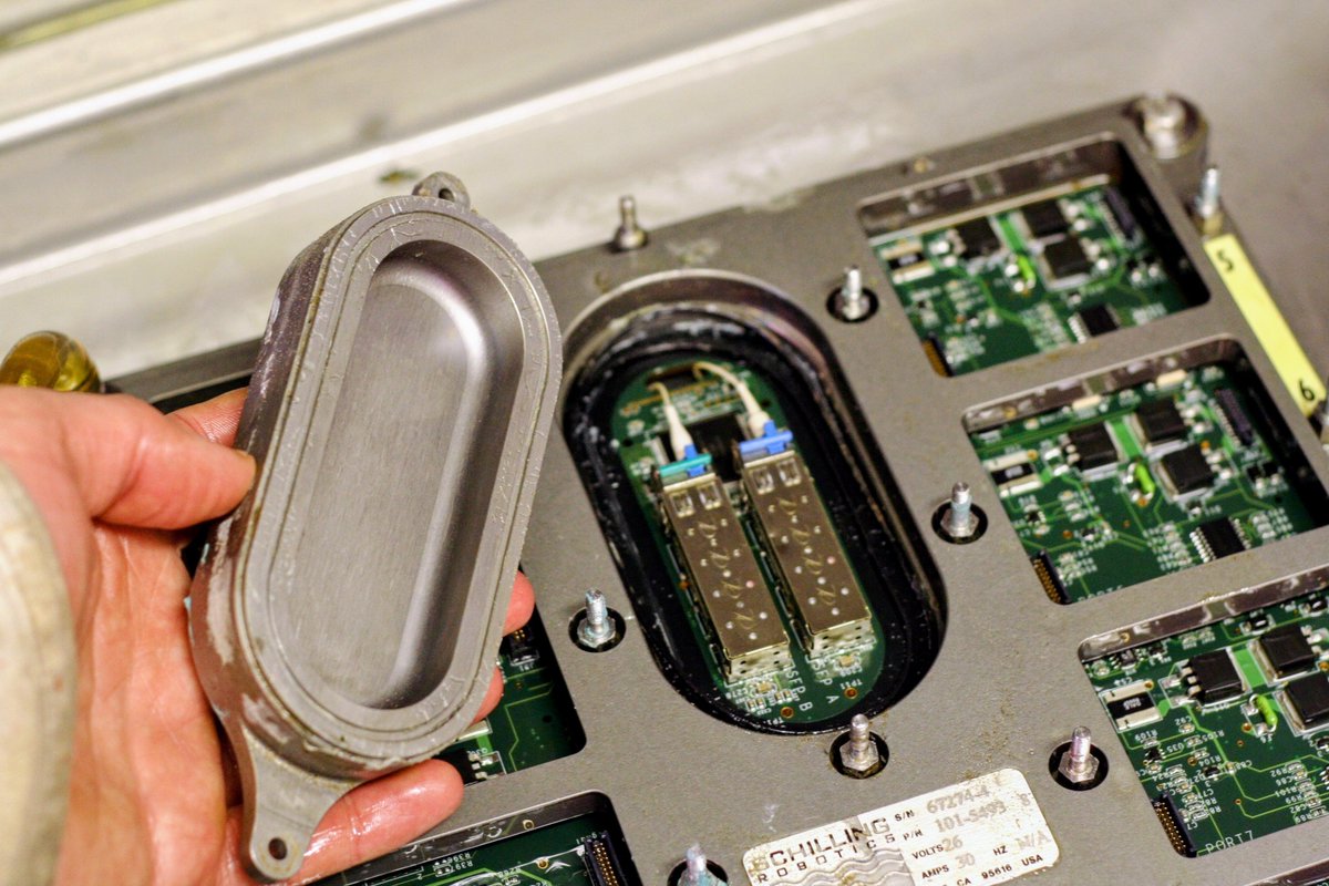 PoseidonROV's tweet photo. Most electronics are not easily crushed
But a few must be protected

Resistors, ceramic caps, and most IC's actually handle 10,000 PSI or more without issue.  Just keep them in clean mineral oil and they will usually handle the pressure.

Laser diodes, electrolytic caps, and quartz crystals however need protection.  

While changing O-rings on this telemetry system housing, you can see the SFP laser modules that are kept under a Titanium dome.  The rest of the electronics are simply helt ina thin housing filled with mineral oil.  

This is a huge cost savings over placing the whole board in a sealed housing rated to thousand of meters deep.

If you need to modify your electronics to handle the deep ocean, please get in touch, as we have spent 2 decades doing this.