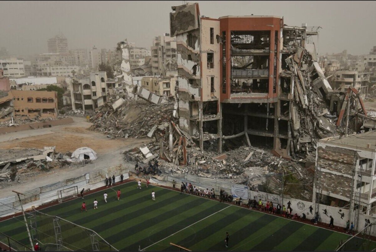 ShehabAgency's tweet photo. 🔵 متابعة شهاب | "صحيفة لومانيتيه": ضغوط مؤيدة لـ "إسرائيل"  تدفع مهرجان دوفيل للصور الرياضية في فرنسا إلى سحب صورة توثق مباراة كرة قدم لشبان فلسطينيين وسط الركام في غزة.

▪️ الصورة، التي التُقطت في 14 فبراير/شباط 2026، توثق مباراة بين نادي غزة الرياضي والنادي الأهلي على ملعب أُعيد تأهيله وسط مبانٍ مدمرة جراء العدوان الإسرائيلي.

▪️ كانت الصورة ضمن الدورة الثانية من المهرجان الذي تنظمه بلدية دوفيل، قبل أن تُسحب من المعرض في 20 أغسطس/آب وتُستبدل بصورة لراكبي دراجات.

▪️ بلدية دوفيل بررت سحب الصورة برغبتها في تجنب إثارة الجدل وعدم جرح مشاعر أحد، فيما أثار القرار انتقادات من سياسيين وحقوقيين في فرنسا وخارجها، اتهموا البلدية بمحاولة إخفاء الإبادة المتواصلة في غزة.