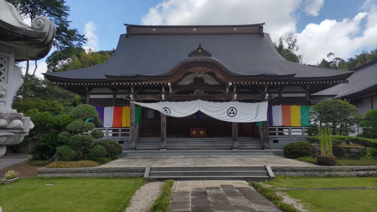 Colonel_yuduki's tweet photo. #結月大佐の御朱印さんぽ 
#真言宗豊山派

『皓月山 靜覺院 宝金剛寺』 
所在地：〒285-0065 千葉県佐倉市直弥38-1

御本尊： 大日如来（金剛界）

宗派： 真言宗豊山派

御朱印：あり 
駐車場：あり

参拝日時：令和8年8月10日（月）午前10時54分頃

---

佐倉市直弥にございます、皓月山 靜覺院 宝金剛寺へ参拝して参りました。

こちらは真言宗豊山派に属する古刹で、御本尊として金剛界大日如来をお祀りしております。

境内へ入ると、まず立派な本堂が目に入ります。

周囲を豊かな緑に囲まれた境内は非常に静かで、広々とした空間の中に本堂や諸堂が整然と配置されております。

本堂の前には大きな石灯籠もあり、芝生や植栽も丁寧に整えられておりました。

本堂には色鮮やかな幡が掛けられており、荘厳な雰囲気がございます。

宝金剛寺の歴史は非常に古く、寺伝によれば源頼朝公との縁が伝えられております。

治承四年（1180）、挙兵した源頼朝公が房総へ逃れた際、当地にあった虚空蔵堂へ止宿したとされております。

その折、源氏の繁昌を祈願したと伝えられ、その後、頼朝公の子である源頼家公の時代にこの話が北条時政へ伝えられます。

頼家公は亡父・頼朝公の菩提と源家の繁昌を願い、北条時政を奉行として建仁年間に堂宇を建立。

寺領三百石と蜀紅錦の七條などが寄進され、入仏の導師を務めたのが覚済僧正であったと伝えられております。

この開山・覚済僧正は関白藤原良経公の五男とされる人物で、顕密二教に通じた高僧であったと伝わります。

一方で、寺は後に火災に遭い、古記録などの多くが焼失。

本尊・法流・開山の袈裟など、わずかなものが残ったとされております。

その後、慶長年間に当地の岩富城主であった北条氏勝によって再建されます。

北条氏勝は宝金剛寺の由緒を重んじ、大檀那となって寺領百石を寄進し、さらに八幡宮のため十石を寄進したと伝えられております。

境内には、この北条氏勝に関係するものと思われる供養塔もございます。

また、氏勝は慶長十四年（1609）に岩富で戦った後、宝金剛寺へ入り、同寺で切腹したとする伝承も残されております。

境内に残る歴史資料の説明板には、北条氏勝の寄進に関係する文書や、寺に伝わる文化財についても詳しく紹介されておりました。

特に目を引いたのが、佐倉市指定文化財となっている「牡丹蓮華唐草模様七条袈裟」などについての説明です。

慶長二年（1597）の資料として紹介されているものもあり、この寺が中世から近世にかけて当地の歴史と深く関わってきたことが窺えます。

境内には本堂のほか、小さなお堂もございます。

その一つには赤い幟が立てられ、地域の信仰が現在にも続いている様子が感じられました。

寺伝によれば、境内にはかつて虚空蔵堂・釈迦堂・大師堂なども存在したとされております。

特に虚空蔵堂は、源頼朝公が止宿したと伝えられる場所であり、弘法大師作とされる虚空蔵菩薩を本尊としていたとのこと。

古くからこの地で信仰を集めてきたことが分かります。

また、境内には大きな石造の灯籠などもあり、歴史ある寺院らしい景観を作っております。

本堂へ参拝した後、寺務所にて御朱印を頂戴いたしました。

今回いただいた御朱印は「大日如来」の御朱印で、中央に大きく御本尊のお名前が揮毫され、宝金剛寺の朱印が押されております。

「皓月山」の文字も添えられており、力強い筆致が印象的な御朱印でございました。

また、境内から少し外へ出ると、田畑と緑の広がる景色を見ることができます。

道路の向こうには高架も見えておりますが、その周囲には豊かな自然が残されており、佐倉の郊外らしい風景となっておりました。

古い歴史を持つ寺院でありながら、現在も地域の中に静かに残されている宝金剛寺。

源頼朝公、源頼家公、北条時政、そして岩富城主・北条氏勝と、鎌倉から戦国・江戸初期へと続く歴史が伝えられていることは、非常に興味深いところでございます。

伝承と史料の双方が残されているため、単に古い寺というだけではなく、佐倉周辺の歴史を考える上でも興味深い寺院であると感じました。

静かな境内で本堂に手を合わせ、長い年月にわたりこの地で守られてきた御本尊・大日如来へ御挨拶を申し上げて参りました。

【備考】 
・山号は「皓月山」 
・院号は「靜覺院」 
・寺号は「宝金剛寺」 
・真言宗豊山派 
・御本尊は金剛界大日如来 
・開山は覚済僧正と伝わる 
・覚済僧正は藤原良経の五男とされる 
・源頼朝公が当地の虚空蔵堂に止宿したとの寺伝あり 
・源頼家公の時代、北条時政を奉行として堂宇を建立したと伝わる 
・寺領三百石、蜀紅錦の七條などが寄進されたとされる 
・後に火災に遭い、古記録などの多くが焼失 
・慶長年間に北条氏勝によって再建 
・北条氏勝が寺領百石を寄進したと伝わる 
・八幡宮にも十石を寄進したとされる 
・北条氏勝が宝金剛寺で切腹したとの伝承あり 
・境内に北条氏勝に関係する墓
・供養塔あり 
・虚空蔵堂、釈迦堂、大師堂などの由緒が伝わる 
・佐倉市指定文化財などの説明板あり 
・古文書や袈裟など、寺に伝わる文化財が紹介されている ・本堂は非常に立派な造り 
・境内は広く、植栽もよく整えられている 
・境内に石灯籠などの石造物あり 
・御朱印あり 
・駐車場あり
・有人寺院 
・参拝時は静かな環境

古刹という言葉がよく似合う、歴史の厚みを感じる宝金剛寺でございました。

源頼朝公の止宿伝承から始まり、源頼家公、北条時政、そして岩富城主・北条氏勝へと繋がる由緒は実に興味深いものでございます。

幾度かの火災や時代の変遷を経ながらも、大日如来を御本尊として今日まで法灯を守っておられることにも、長い寺院の歴史を感じますな。

今回は御朱印も頂戴することができ、静かな境内と美しく整えられた本堂を拝しながら、ゆっくりと参拝させていただきました。

佐倉市の歴史を知る上でも、一度は訪れておきたい寺院の一つでございます。

#寺院巡り #寺院参拝 #千葉県の寺院 #佐倉市の寺院 #佐倉市 #宝金剛寺 #真言宗豊山派 #大日如来 #源頼朝 #源頼家 #北条時政 #北条氏勝 #岩富城 #御朱印 #御朱印さんぽ #結月大佐の御朱印さんぽ
