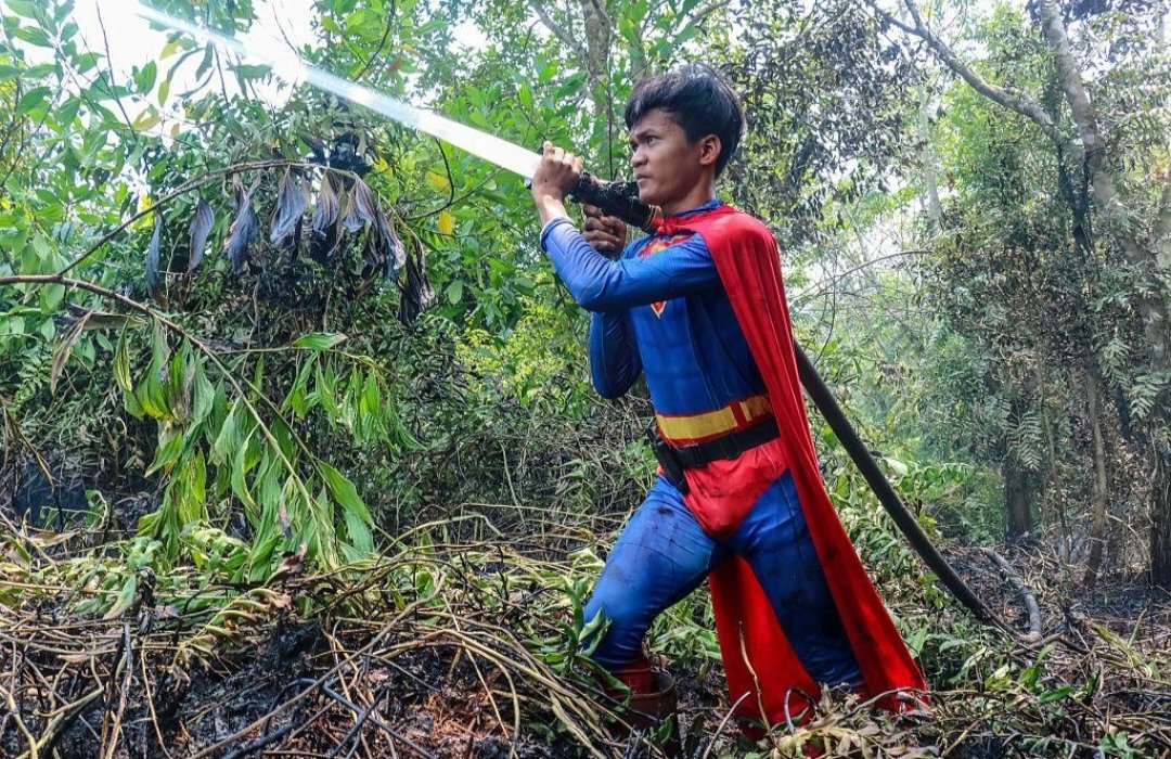 wildwirenews's tweet photo. A 17 year old is fighting wildfires in a Superman costume.

Rudiyansah has been helping his father battle fires in Borneo after school. https://t.co/8QcbkyrAOl