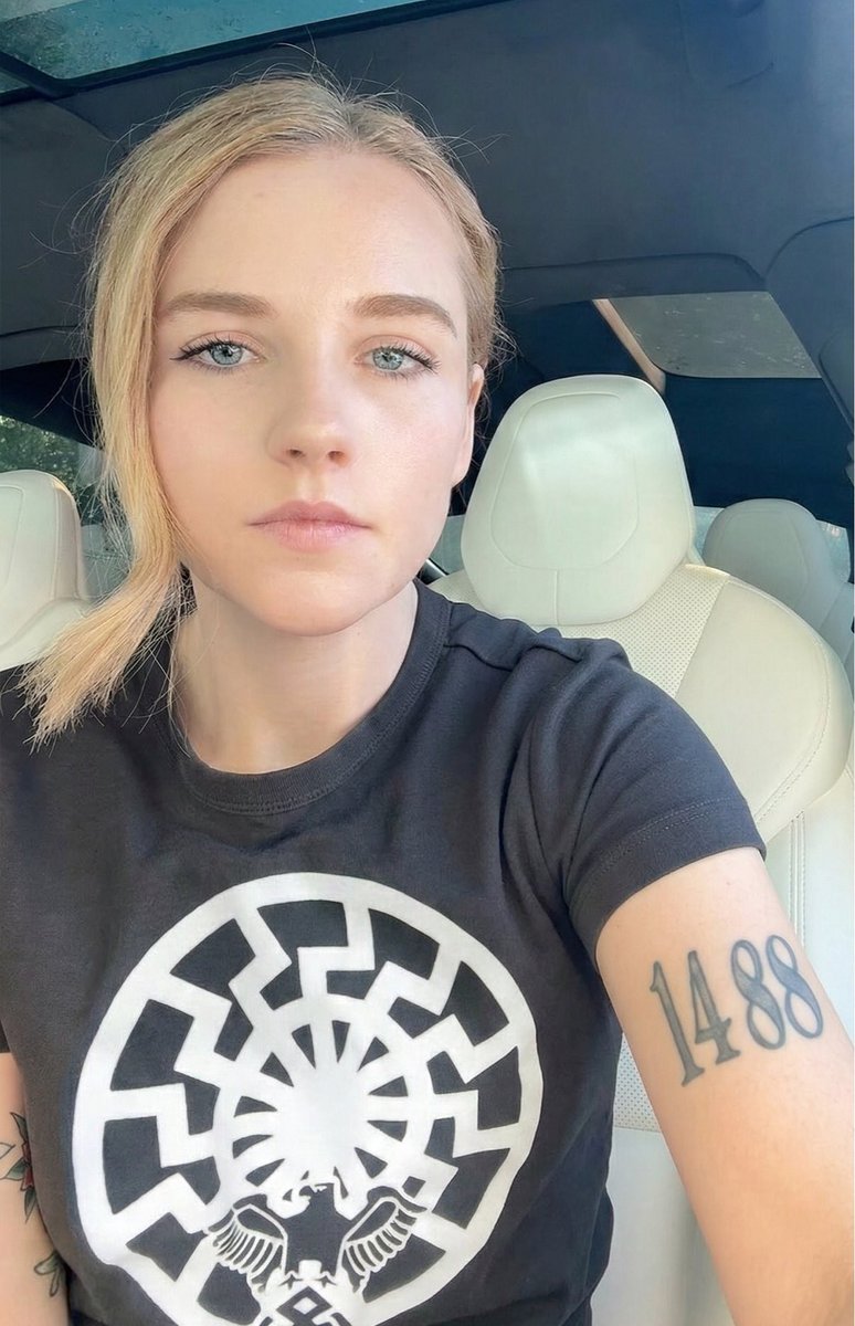 ShaktiFlo's tweet photo. No AI here! You can tell this gal’s for real: photographic quality, realistic tattoo, wrinkles on her shirt, including the unique design of the eagle with rune on the sonnenrad. ❤️ https://t.co/29UBRAkyQv
