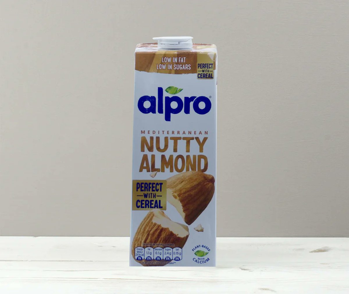 SamaHoole's tweet photo. Your almond milk is two per cent almonds, and the only reason you have never seen that number is that you live in the wrong country.

The British carton has to print it. Alpro, Almond Breeze, there on the side, two per cent. The American carton does not, because the FDA has never required it. Same company, same product, two continents, owning up on one of them.

The rest is filtered water, calcium carbonate, potassium citrate, sunflower lecithin, gellan gum and natural flavours.

Calcium carbonate is chalk.

Which gives us the finest sentence printed on any carton in that fridge. Fifty per cent more calcium than milk. Perfectly true, because they tipped it in.

A cup gives you one gram of protein. The milk it replaced gives you eight, and does not need a gum to stay together in a cup of tea.

Every February, America moves its bees for this. Around eighty per cent of every honey-producing colony in the country, onto flatbed lorries, driven to California, because a million acres of almond trees flower at once and not one can pollinate itself. Forty eight billion bees, working an orchard the size of Rhode Island, in service of a beverage that is mostly tap water.

The hives get stolen, because they are worth stealing. When the lorries crash, recapturing the bees costs more than they are worth, so the fire brigade kills the survivors at the roadside with soapy water.

Lately they have been arriving dead anyway. Operators opening truck after truck in the Central Valley and finding half the boxes finished before they got there.

Then the water. California grows eighty per cent of the world's almonds in a state that keeps running dry, and the biggest growers are Stewart and Lynda Resnick, who also own the pomegranate juice a federal court found had been deceptively advertised. In 1994, behind closed doors at a resort in Monterey, California's water arrangements were rewritten and the Resnicks came away with fifty seven per cent of the Kern Water Bank, built with public money. By 2021 that stake was worth over a billion.

Public asset in. Private water out. Sold back at a markup.

Two pounds a carton.

And this was the kind option.

The cow stood in a field in the rain the whole time, doing all of it herself, for nothing.