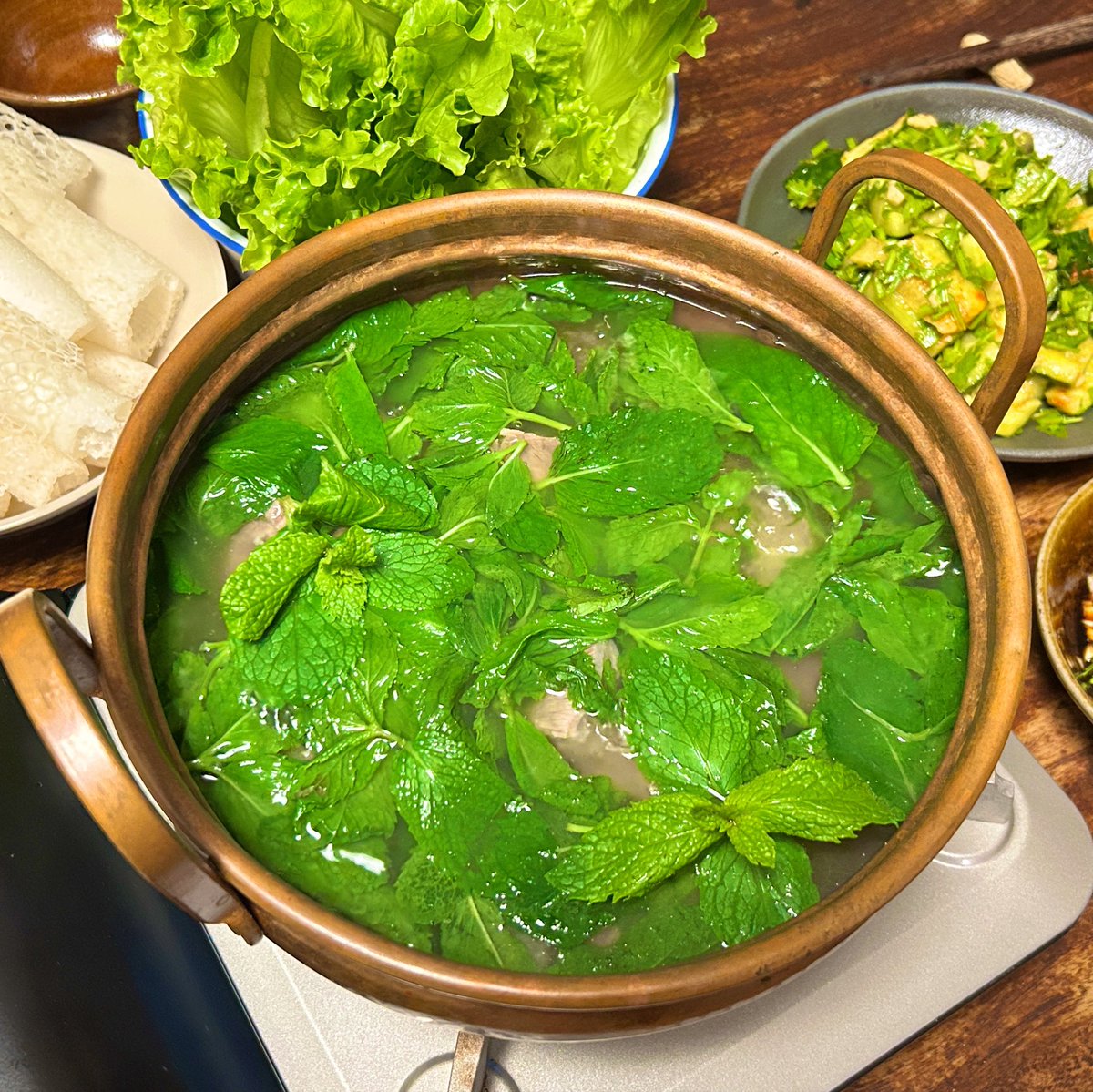 shutozennin's tweet photo. 上海に戻っても雲南熱冷めやらず、薄荷牛肉湯（ミントと牛肉のスープ）。じっくり牛すじ肉を煮込んだスープに「これでもか！」って量のミントをドサッ。煮えばなを肉にからめ、激辛薬味だれにつけて食べる。口の中に溢れる香りと辛味。初めて食べた時の衝撃からはや十数年、何度作ってもやはりうまい。 https://t.co/k68CmfLcBS