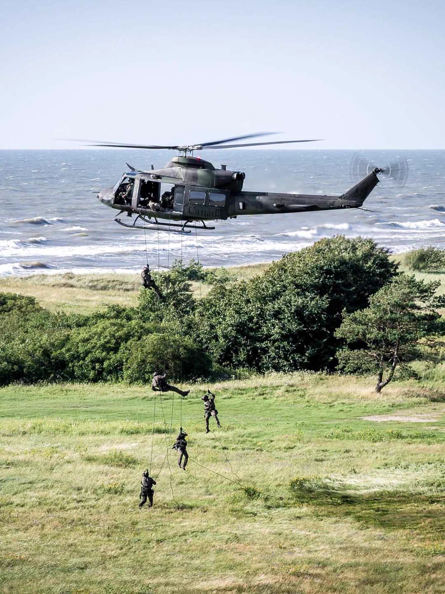 Soldiers lowering down from a helicopter