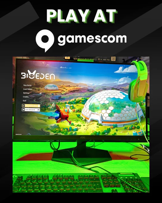 Computer setup showcasing the game BioEden on screen with a green gaming headset hanging on the monitor at Gamescom.
