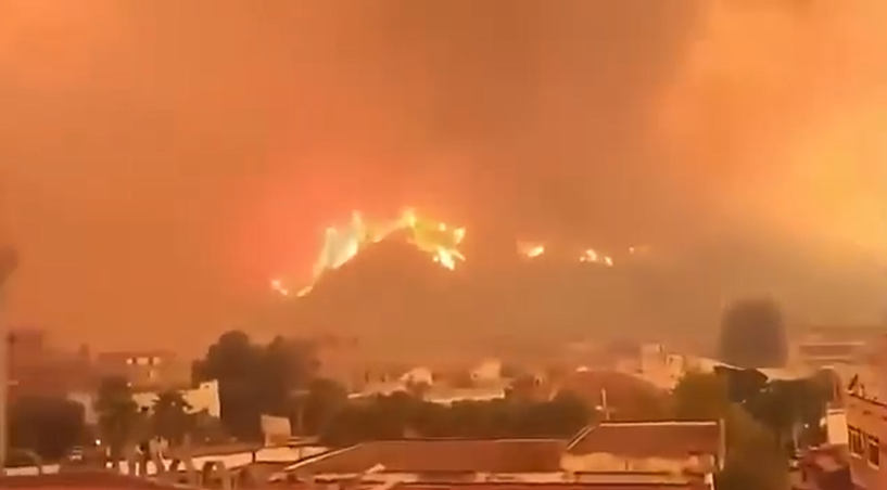 volcaholic1's tweet photo. Severe wildfires fueled by extreme heat have devastated Algeria's Jijel Province, forcing mass evacuations. In El Ancer, massive smoke plumes completely blocked out daylight, turning the sky dark. 

Local mosques broadcast emergency prayer calls from minarets to warn residents as flames approached homes. 

The blazes have turned deadly, causing at least 12 fatalities across the region.