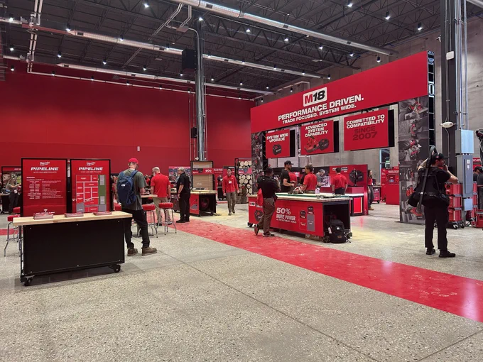 Interior of Milwaukee PIPELINE 2026 event space featuring red M18 product displays, demonstration stations and attendees exploring new Milwaukee Tool products under the tagline "Performance Driven. Trade Focused. System Wide.”