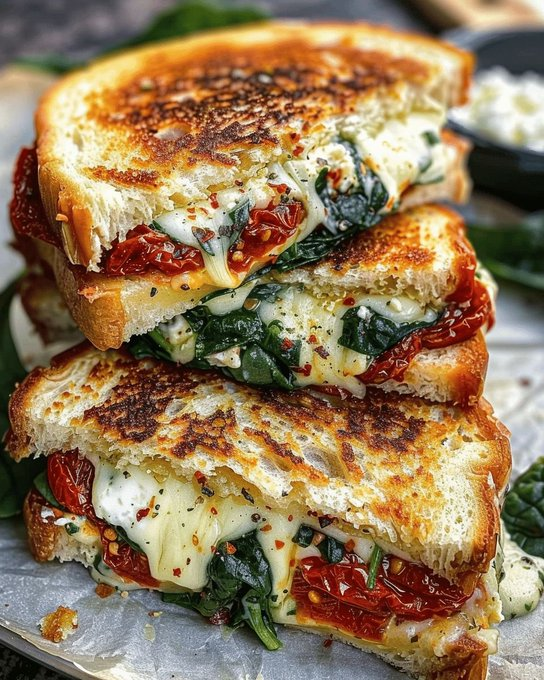 ann_ann886's tweet photo. Sun-Dried Tomato, Spinach, and Ricotta Grilled Cheese

Serves: 2 sandwiches • Prep: 10 minutes • Cook: 10 minutes • Total: ~20 minutes

Ingredients
For the filling
1 tbsp olive oil
2 cups baby spinach
1 small garlic clove, minced
1/3 cup ricotta
1/2 cup shredded mozzarella or 4 slices fresh mozzarella
1/4 cup grated Parmesan
1/3 cup sun-dried tomatoes, sliced
1/4 tsp dried oregano
Pinch red pepper flakes
Salt and black pepper, to taste
For the sandwiches
4 slices thick sourdough or rustic bread
2 tbsp butter, softened
or mayo for spreading on the outside

Instructions
1. Cook the spinach
Heat olive oil in a skillet over medium heat.
Add garlic and cook for 20 seconds.
Add spinach and cook 1–2 minutes, just until wilted.
Season lightly with salt and pepper, then remove from heat.
2. Mix the cheese layer
In a small bowl, stir together ricotta, Parmesan, oregano, a pinch of black pepper, and red pepper flakes.
3. Build the sandwiches
Spread butter on one side of each bread slice.
On the unbuttered side, spread the ricotta mixture.
Add mozzarella, wilted spinach, and sun-dried tomatoes.
Close with the second bread slice, buttered side facing out.
4. Grill
Heat a skillet or griddle over medium-low heat.
Cook the sandwiches for 3–4 minutes per side, pressing gently, until the bread is deep golden and crisp and the cheese is melted.
Lower the heat if the bread browns too fast before the center melts.
5. Serve
Let rest 1 minute, then slice and serve hot.

Tips
Medium-low heat gives you a crisp crust and fully melted center.
Pat the sun-dried tomatoes dry if they’re very oily.
A mix of ricotta + mozzarella gives both creaminess and that melty cheese pull.
Add a little feta or goat cheese if you want a tangier Mediterranean flavor.

Optional add-ins
Fresh basil
Cooked chicken
Pesto
Caramelized onions