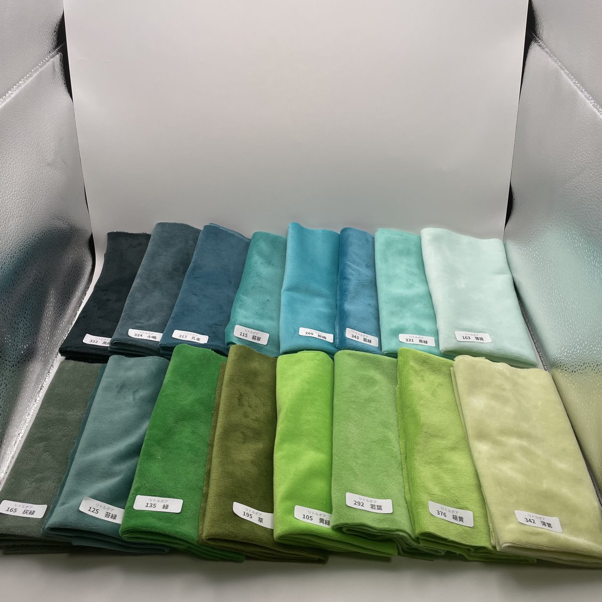 katagamikiyotak's tweet photo. 【本日連続投稿！リトルボア36cm｜緑・青緑・黄緑系の色比較】

本日2回目の色比較投稿です！
今回は、新色を含む緑・青緑・黄緑系の16色を並べて撮影しました。

■上段・左から
黒緑322／小鴨324／孔雀317／翡翠115／新橋269／藍緑343／青緑331／薄荷163

■下段・左から
灰緑165／苔緑125／緑135／草195／黄緑105／若葉292／萌黄376／薄鶯342

このうち、今回追加した新色は
小鴨324／孔雀317／翡翠115／灰緑165／若葉292／萌黄376／薄鶯342
の7色です。

1枚目と2枚目は中間色、3枚目は暖色、4枚目は寒色の照明で撮影しています。

閲覧環境によっても色の見え方は異なりますが、各色の違いや濃淡を比べる際の参考にしていただければと思います。

■サイズ：約36×36cm
■価格：1枚242円（税込）
■全61色

各色はこちらからご覧いただけます。
商品一覧
https://t.co/Xe5pGwu08E
生地色比較ページ
https://t.co/ps8hJyJMDr

残りの色も、また後日撮影してご紹介していきます！

#型紙清竹 #ぬいぐるみ #ぬい活 #ぬいぐるみ作り #ぬい生地 #ソフトボア #リトルボア