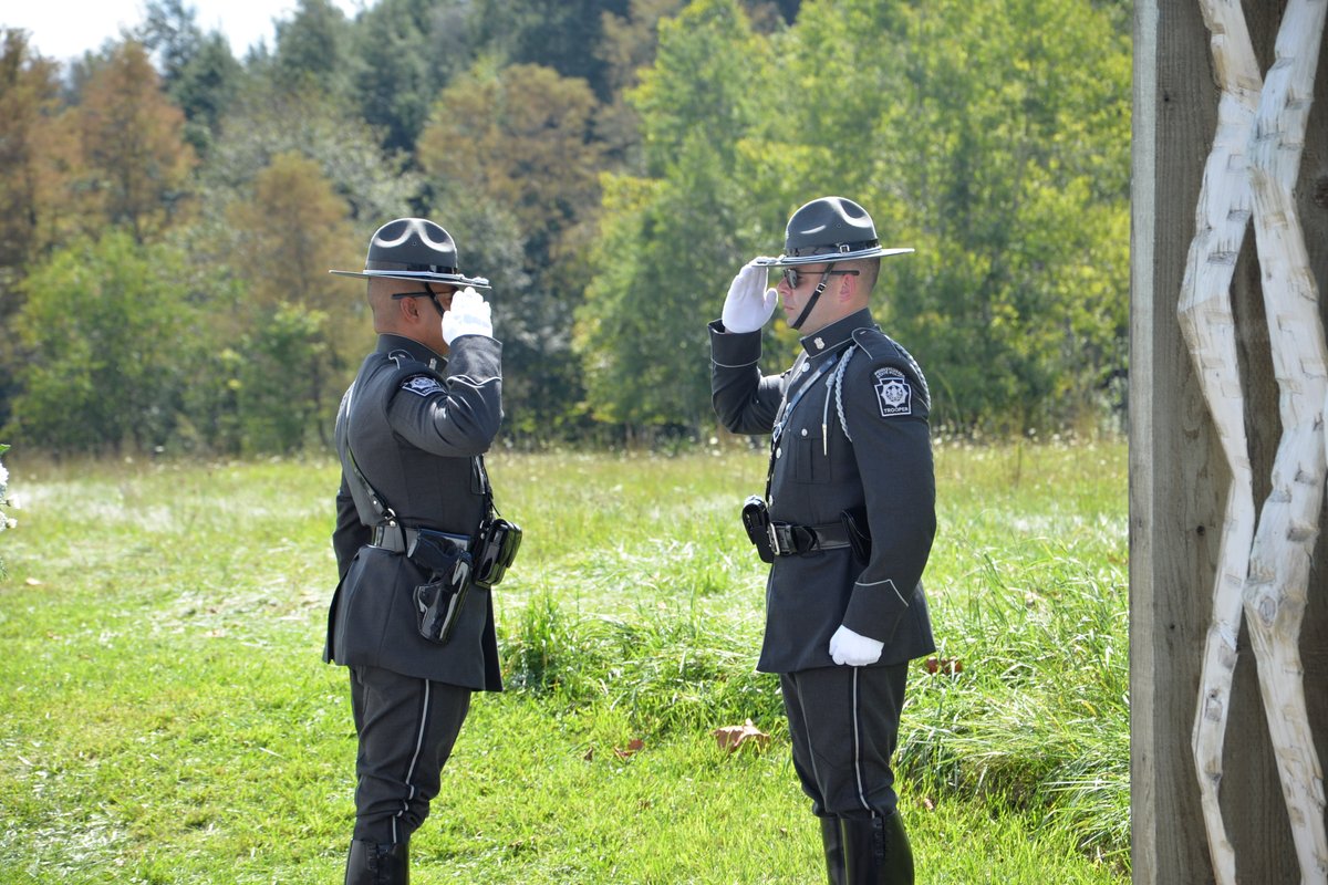 Two Pennsylvania State Police Troopers salute each other during a ceremony at the Flight 93 National Memorial.