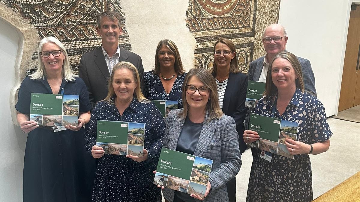 VisitEngland Deputy Director Lyndsey Turner Swift and VisitEngland Regional Development Lead for South West England Robin Tjolle join attendees at the launch of the Dorset Management Plan at Dorset Museum & Gallery.
Nine people pose with Dorset Management Plan brochures with a wall mounted brown and white mosaic in the background.