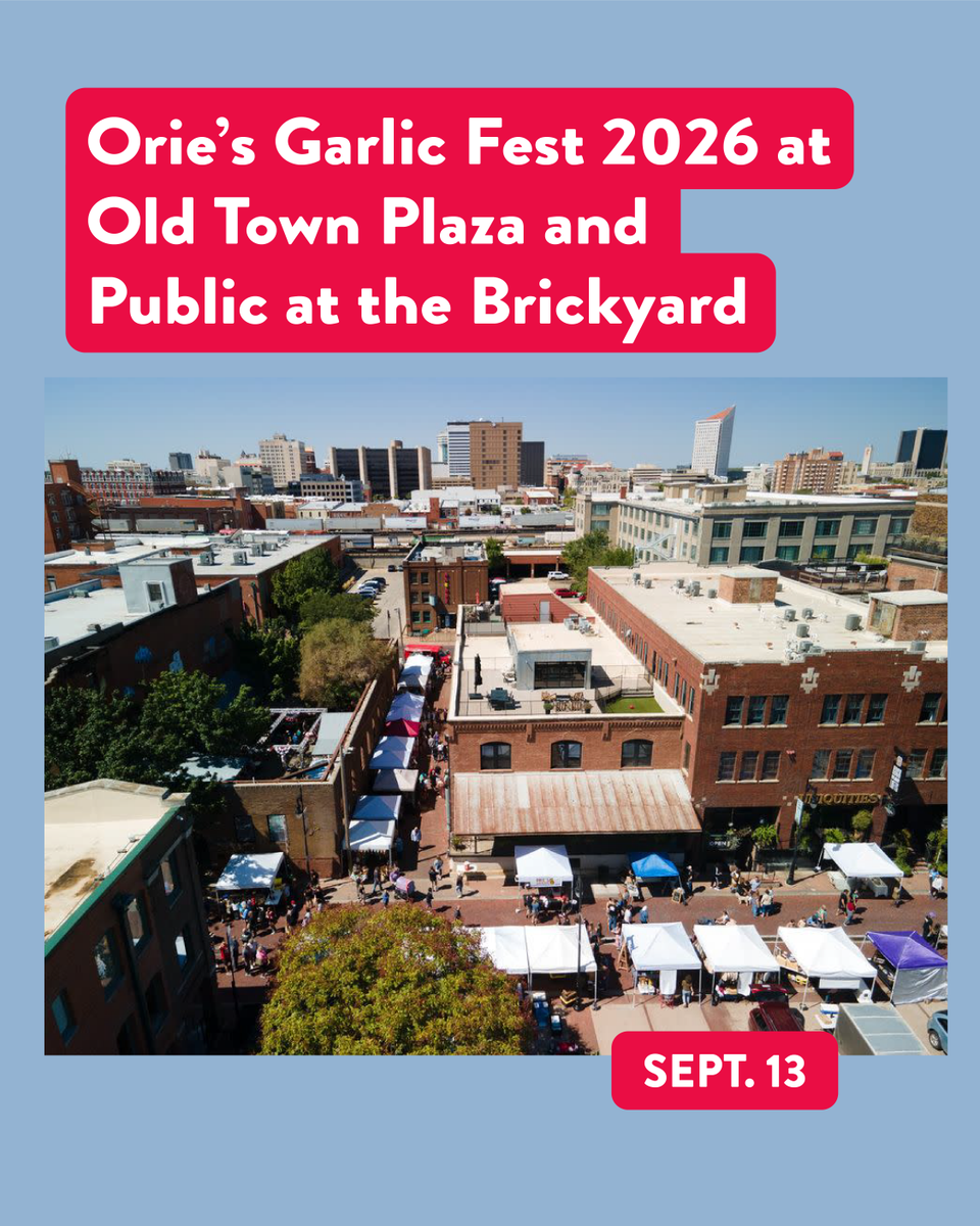 Aerial view of a busy outdoor festival with numerous tents and booths lining a plaza. Buildings surround the plaza, and a crowd is visible. Text on the image reads: "Orie’s Garlic Fest 2026 at Old Town Plaza and Public at the Brickyard" and "Sept. 13.