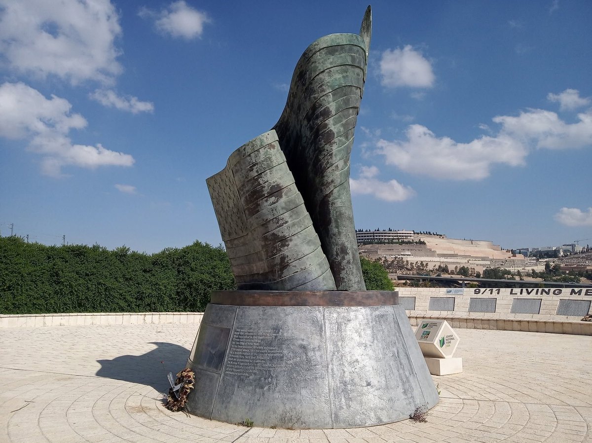 VerminusM's tweet photo. A few years ago, one of my classes got canceled, so I went for a walk in the hills near Jerusalem. After walking through the woods for a bit, I came by a monument to the victims of 9/11, overlooking Jerusalem's famous Har HaMenuchot cemetery.
It's a handsome monument that depicts a flame made from the American flag with a piece of metal taken from the ruins of the Twin Towers displaying inside the base.
The names of the victims are inscribed in stone around the statue. As far as I know, this is the only monument with the names of all the victims outside of the United States. 
May their memory be a blessing.