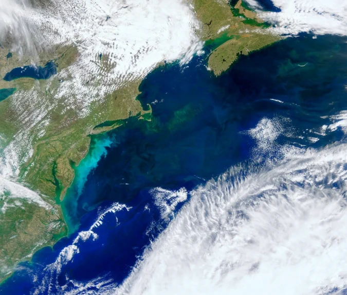True color satellite image showing a phytoplankton bloom off the U.S. East Coast in May 2024. The bloom looks like a milky, bright blue swirl just off the coast. Credit: NASA