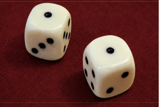 Two white dice with black dots resting on a red felt surface.