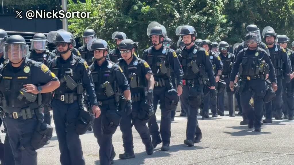MemeMartin35717's tweet photo. Texas Doesn’t Do Liberal Chaos: Cops Shut Down Leftist Circus Outside Trump’s Dallas Convention

Dallas police in riot gear rolled up Thursday outside the American Airlines Center and put a hard stop on the usual left-wing street theater. Officers surged into position to keep agitators from turning the RNC midterm convention into another burned-out blue-city sideshow. Roads got blocked. Crowds got contained. And Texas, once again, reminded the country it is not Portland, not Seattle, and not whatever sanctuary dump Democrats keep pretending is “mostly peaceful.”

The video out of Victory Park tells the story. Lines of geared-up officers moved in while protesters marched with the same recycled signs: Trump, fascism, Iran, the whole catalog of grievances that never seems to include the wreckage their own policies leave behind. They wanted chaos. They got a perimeter. That is the difference between a red state that still believes in order and a left that treats riots as a branding exercise.

President Trump was heading back to the venue for a closed-door RNC roundtable and a speech later in the night. The man keeps working. The professional outrage class keeps yelling from the sidewalk. One side is trying to hold a convention and win midterms. The other side is trying to make sure nobody can get there without a lecture and a traffic jam.

Dallas prepared for this. Street closures. Checkpoints. Secret Service. Local, state, and federal cops. Nearly two million dollars in security because the modern left cannot be trusted to protest without trying to grind a city to a halt. Organizers from the usual coalition of progressive groups planned a march from Pike Park toward the arena. Police worked the scene instead of handing them the streets. That is how it is supposed to work.