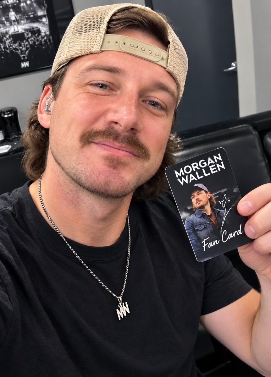 Morganmlug's tweet photo. A clean, natural-looking selfie showing the man wearing a backward beige cap and black shirt while holding a Morgan Wallen fan card. The simple backstage-style setting keeps the focus on him and the card.
#morganmlug https://t.co/q7KcoOS1Bv