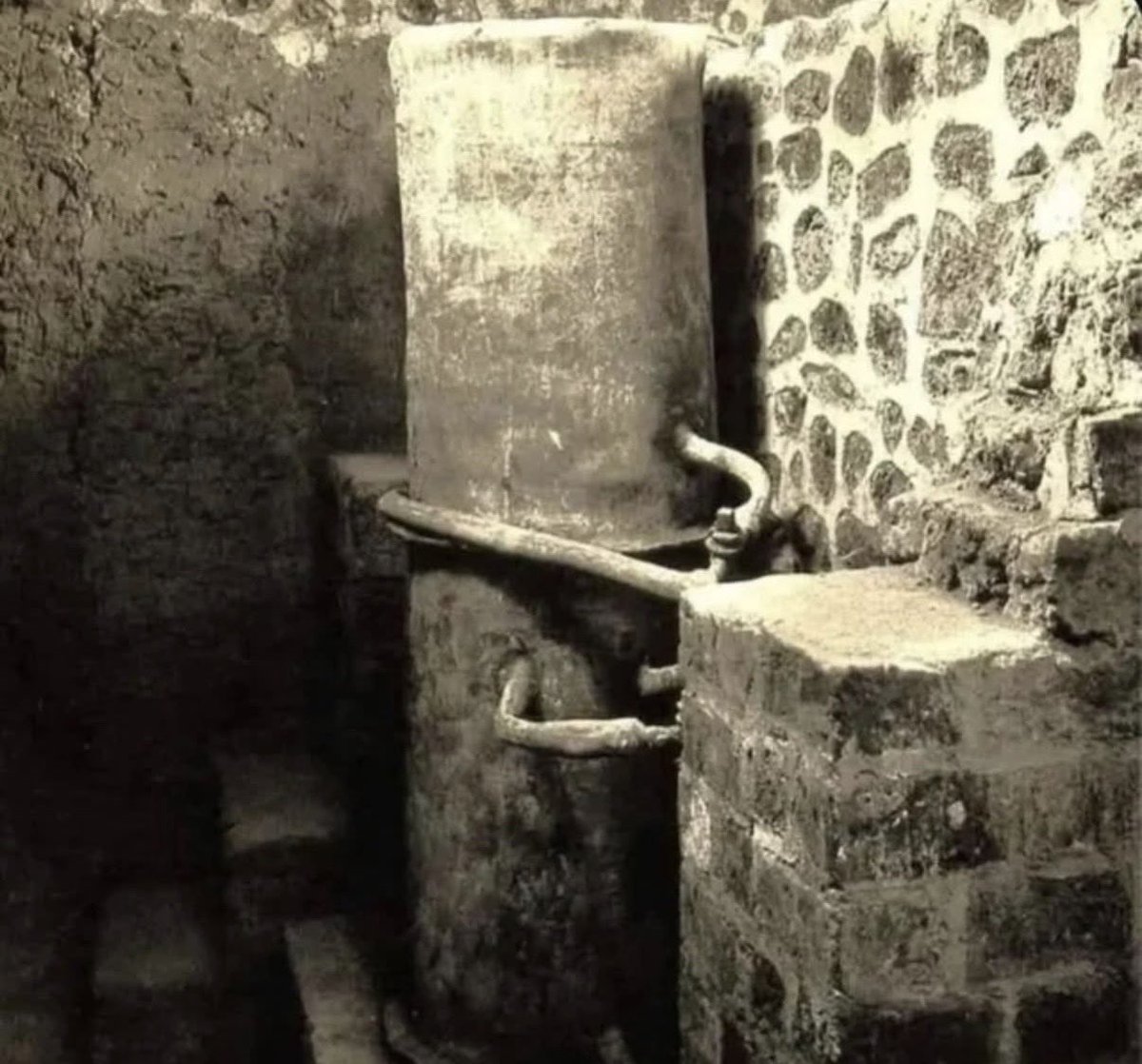 historyinmemes's tweet photo. A Roman water boiler dating to the 1st century BC was discovered in a villa in Boscoreale, Italy. Remarkably, it survived with its network of pipes and fittings intact, making it one of the rarest and best-preserved examples of ancient Roman plumbing technology.

The boiler was uncovered in 1896 within the private bath complex of Villa della Pisanella, a Roman country estate near Pompeii. Its remarkable preservation offers archaeologists a rare glimpse into how wealthy Romans heated and circulated water more than 2,000 years ago.

The system featured a cold-water reservoir linked by lead pipes to a cylindrical metal boiler called a miliarium. Heated from below by a furnace, the boiler worked alongside pipes, valves, and taps that directed hot and cold water throughout the villa’s bathing rooms.

This sophisticated setup allowed residents to pass between hot, warm, and cold bathing areas, providing an experience similar to the elaborate facilities typically found in large Roman public bathhouses.

Villa della Pisanella was more than an elegant residence. It also functioned as a productive agricultural estate, complete with storage areas, wine presses, animal stalls, and numerous large containers buried underground for storing wine. The villa shows how prosperous rural estates combined agricultural production with the luxuries enjoyed by Rome’s upper class.

The villa and much of its equipment were preserved when Mount Vesuvius buried the Boscoreale area during the eruption of AD 79. Because ancient metal plumbing was often removed and melted down in later centuries, the survival of such a complete system is exceptionally uncommon.

Villa della Pisanella was also the site of the Boscoreale Treasure, a collection of more than 100 pieces of Roman silverware. The valuable objects had been concealed inside a storage cistern before the eruption of Vesuvius.