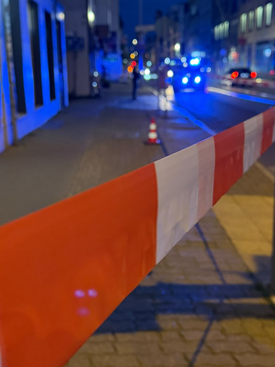 Eine polizeiliche Absperrung über einen Gehweg.