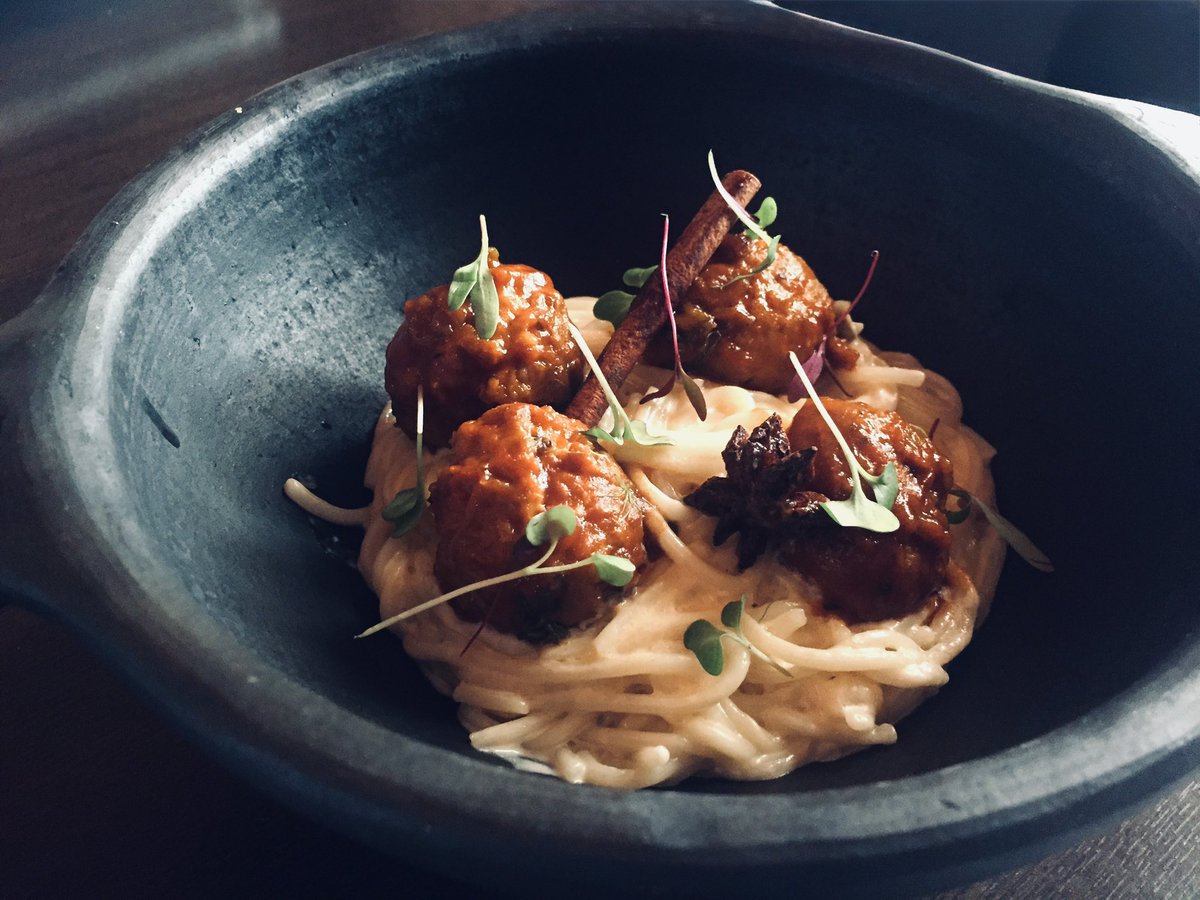 andresmadrigalg's tweet photo. Alguien me escribió por privado preguntando por una receta rica, de esas que no fallan con amigos. Pensé en un plato que preparé hace poco y que me dio muchas alegrías: unas albóndigas especiadas sobre unos soberbios tonnarelli cacio e pepe. Como sabéis, me fascina la cocina italiana, pero esta receta tiene un trasfondo que va mucho más allá de Roma. Cruza el Mediterráneo a través de algo tan humilde como una bola de carne picada. Mientras coloco la tabla de cortar en mi encimera, no puedo evitar sonreír al recordar el año 2000. Aquel año publiqué un libro dedicado a rastrear las raíces árabes, judías y cristianas de nuestra gastronomía, el cual fue premiado en Périgueux como el mejor libro de cocina del chef del mundo. En sus páginas ya hablaba del viaje de las albóndigas, y hoy me sigo maravillando de su historia.
La albóndiga es el mapa del mundo comestible. Su origen nos lleva a la antigua Persia, donde las llamaban kofta(carne machacada). El mundo árabe adoptó la fórmula y nos la heredó como al-bunduq ("la bola"). Ellos nos enseñaron a moldearlas, freírlas en buen aceite y jugar con los aromas. Cambian de nombre según el puerto donde atraquen: en Italia son polpette, en Francia boulettes, en Inglaterra meatballs, en Japón tsukune y en Corea del Sur wanja. Todos los pueblos han tenido la necesidad de aprovechar cortes de carne mezclándolos con pan y huevo. Esa cercanía las hizo iconos de la cultura visual, desde la entrañable cena en La dama y el vagabundo hasta la parodia de Lluvia de albóndigas. Evocan hospitalidad. Su toque de hoy viene del Norte de África; me inspiro en el maravilloso Tajine de Kefta marroquí, ese guiso aromatizado con canela, comino y anís estrellado. Esa calidez es la que traslado a mis polpette, uniéndolas a una de las salsas de queso y pimienta más puras del recetario romano.
Para empezar, pongo en un bol medio kilo de carne picada de ternera. Añado un huevo, cincuenta gramos de miga de pan empapada en leche y escurrida, y un diente de ajo picado. Incorporo una pizca de comino y otra de canela en polvo, con su punto de sal y pimienta. Con las manos limpias, trabajo la masa con suavidad y moldeo bolitas medianas. En una sartén con aceite de oliva caliente, echo las albóndigas junto con una rama de canela entera y una pieza de anís estrellado. Solo quiero que el aceite capte esos aromas sutiles mientras la carne se dora por fuera.
En este punto, introduzco el verdadero puente cultural del plato: paso las albóndigas doradas a una olla donde tengo una muy buena salsa española de fondo oscuro casero. Las dejo cocer allí unos minutos. Es una simbiosis maravillosa; la carne se impregna de la profundidad de nuestro guiso tradicional mientras que la salsa absorbe todos los matices de las especias.
Mientras tanto, cuezo los tonnarelli en poca agua hirviendo con sal para concentrar el almidón. Los saco un par de minutos antes de estar al dente y guardo una taza grande de esa agua. Aparte, en un bol pongo ciento en cincuenta gramos de queso Pecorino Romano rallado y pimienta negra en grano recién tostada y machacada en mortero. Vierto poco a poco el agua caliente sobre el queso mientras remuevo con varillas fuera del fuego hasta crear una crema densa y lisa.
Vuelco la pasta directamente en la sartén templada donde se cruzaron los aceites y jugos de las albóndigas. Añado la crema de queso y manteco con brío; el almidón unirá todo en una emulsión perfecta. Finalmente, sirvo la pasta cremosa en boles hondos de barro, coloco encima las polpette glaseadas en su salsa especiada y corono con unos brotes verdes frescos. Un plato humilde, lleno de viajes y perfecto para compartir sin prisas.