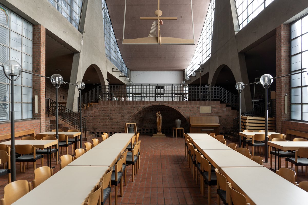 johannkoenig's tweet photo. When we transformed Heilig Geist in Essen into a space for contemporary art, we deliberately chose not to turn the church into a conventional white cube.

Instead, we wanted to work with what was already there. Churches have an atmosphere that is difficult to reproduce in a newly built exhibition space. Their proportions, light, height, materials and acoustics can remove us, at least temporarily, from everyday life.

In that sense, there is an interesting parallel between church and museum architecture. Both create spaces where particular objects are separated from ordinary life and given special attention. Both use architecture to slow us down, direct our movement and influence the way we look.

For centuries, the Church was also one of the most important patrons of architecture and art, commissioning extraordinary buildings and giving architects opportunities to create spaces that went beyond the purely functional.

Heilig Geist is a wonderful example. Designed by Dominikus and Gottfried Böhm, the church is an extraordinary achievement of post-war architecture. Its long central nave is intersected by a slightly displaced square, while triangular concrete pylons support the tent-like roof. Large glazed sections allow light to enter above the lower brick side aisles.

When we converted the building, the most important decision was not what to add, but what not to destroy. Later interventions were removed to reactivate the original lighting concept. The pews disappeared, while the historic brick floor was preserved. The walls received a reversible white limewash, and new functional elements were kept subordinate to the architecture.

The result isn’t really a museum inside a church. It is still unmistakably a church, but one in which contemporary art can create new experiences.

At a moment when more churches are losing their original use, perhaps we shouldn’t ask only what to do with them, but what we can do because of them.

For me, contemporary art is one very good answer.

#HeiligGeist #ChurchArchitecture

© Image by Felix Hemmers