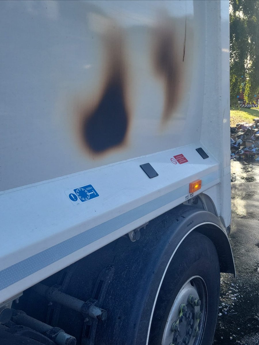 The side of a refuse truck with visible burn marks