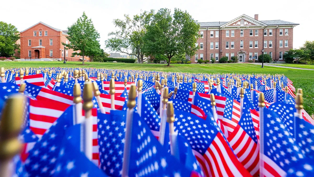 Display of flags with East Hall in the background on September 11, 2026. Photo: Alonso Nichols/Tufts University. 
