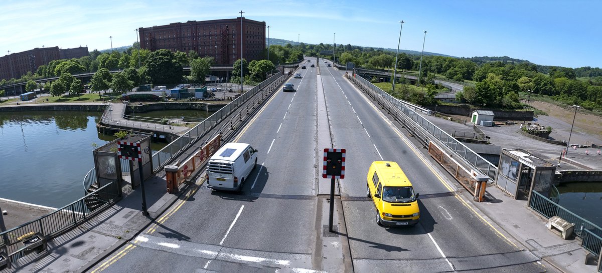 A wide-angle view of Plimsoll Bridge with a white van and a yellow van driving in opposite directions on a sunny day.