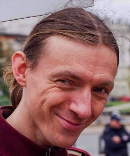 lkwarzecha's tweet photo. Bardzo ciekawy wpis na facebookowym profilu Activist Watch (polecam), który przeklejam w całości. 
O sprawie planów ogólnych trzeba pisać, bo ich skutki dla nawet nie setek tysięcy, ale milionów Polaków mogą być DRUZGOCĄCE i iść w miliardy złotych strat wartości działek. 
Coraz bardziej nasuwa się pytanie: cui bono? Kto na tym zyskał? Komu to było potrzebne i po co?
(Na zdjęciu bohater wpisu.)

Reforma planowania przestrzennego, która może zmienić wartość tysięcy polskich działek, nie narodziła się po wyborach w 2023 roku.
Jej początki sięgają czasów rządów Zjednoczonej Prawicy.
To właśnie wtedy, około 2019–2020 roku, Robert Buciak trafił do administracji rządowej, a w 2020 roku był już związany z Departamentem Planowania Przestrzennego Ministerstwa Rozwoju.
Polską rządził Mateusz Morawiecki, a resortem rozwoju kierowała Jadwiga Emilewicz z Porozumienia.
Później ministerstwem kierował Jarosław Gowin.
To za tych rządów rozpoczęły się prace nad reformą, która kilka lat później miała przewrócić dotychczasowy system planowania do góry nogami.
Kim był człowiek, który znalazł się w środku tego procesu?
Buciak nie jest politykiem, nie był ministrem i nie ma podstaw do twierdzenia, że należał do PiS czy Porozumienia.
Nie jest też – przynajmniej w dostępnych oficjalnych materiałach – przedstawiany jako architekt czy urbanista posiadający takie kwalifikacje.
Jego wcześniejsza kariera związana była https://t.co/bqlkg7L119. ze statystyką regionalną, a sam przedstawia się jako absolwent Międzywydziałowych Indywidualnych Studiów Matematyczno-Przyrodniczych UW.
Krótko mówiąc: człowiek od danych, statystyki i analiz przestrzennych trafił do departamentu, który zaczął przygotowywać fundamentalną zmianę zasad zabudowy w Polsce.
I właśnie tutaj robi się ciekawie.
W 2020 roku ministerstwo rozpoczęło prace nad nowym systemem planowania.
W 2021 roku powstawały kolejne założenia i projekty, a pod koniec roku reforma wchodziła już w fazę formalnych uzgodnień.
W 2022 roku projekt był konsultowany i uzgadniany międzyresortowo.
Nie był to więc spontaniczny pomysł jednego ministra, lecz wieloletnia praca urzędniczego aparatu.
Buciak był częścią tego aparatu.
W 2023 roku występował przed komisjami Sejmu jako główny specjalista Departamentu Planowania Przestrzennego MRiT.
Co więcej, przedstawiciele ministerstwa oddawali mu głos przy omawianiu konkretnych przepisów, a sam Buciak wskazywał, że kierował pracami zespołu rewitalizacji.
W 2026 roku nadal pozostaje związany z tym departamentem, który odpowiada za rozwiązania systemowe w zakresie planowania przestrzennego i wdrażanie reformy.
A sama reforma?
Jej najważniejszym elementem stał się plan ogólny gminy.
To on ma określać, gdzie i w jakich strefach będzie możliwa zabudowa.
Wprowadzono również obszary uzupełnienia zabudowy, od których zależy możliwość uzyskania wielu decyzji o warunkach zabudowy.
Brzmi niewinnie: „ład przestrzenny”, „miasto kompaktowe”, „ograniczenie chaosu”.
Problem polega na tym, że za tymi eleganckimi określeniami stoją konkretne działki i konkretne pieniądze.
Działka, która dzisiaj ma potencjał budowlany, niekoniecznie będzie miała taki sam potencjał po uchwaleniu planu ogólnego.
Jeżeli zostanie wyłączona z odpowiedniego obszaru, właściciel może mieć znacznie większy problem z uzyskaniem WZ.
A różnica między działką, na której można zbudować kilka domów, a działką bez realnego potencjału inwestycyjnego może wynosić setki tysięcy złotych.
I tutaj pojawia się najbardziej niewygodne pytanie.
Czy państwo rzeczywiście tylko „porządkuje przestrzeń”, czy przy okazji decyduje, które działki zachowają swoją wartość inwestycyjną?
Bo kiedy urzędnicza kreska na mapie rozdziela teren na „możliwy do zabudowy” i „problemowy”, ta kreska może mieć wartość większą niż niejeden dom.
Nie oznacza to oczywiście, że Robert Buciak osobiście decyduje, kto może budować.
Nie oznacza również, że sam wymyślił reformę.
Był i jest urzędnikiem pracującym w departamencie odpowiedzialnym za jej przygotowanie i wdrażanie.
W 2024 roku reprezentował MRiT również w grupie roboczej dotyczącej klas przeznaczenia terenów w planach miejscowych.
A w 2026 roku dyrektor departamentu nadal przekazywał mu głos przy omawianiu przepisów.
I tu dochodzimy do paradoksu całej historii.
Politycy zmieniają się przy urnach, ministrowie zmieniają gabinety, partie zmieniają miejsca w ławach sejmowych, a urzędnicy zajmujący się szczegółami reform pozostają.
Reforma rozpoczęta za rządów Zjednoczonej Prawicy jest więc dziś wdrażana przez kolejne kierownictwa resortu.
Buciak jest jednym z przykładów tej administracyjnej ciągłości.
Dla przeciętnego właściciela działki cała sprawa może wyglądać banalnie.
Kupił ziemię za własne pieniądze i zakładał, że kiedyś wybuduje tam dom albo sprzeda ją komuś, kto to zrobi.
Teraz musi śledzić plan ogólny, strefę planistyczną, obszar uzupełnienia zabudowy i kolejne zmiany ustawy.
Czyli dokładnie to, czego każdy obywatel marzy, aby nauczyć się po zakupie działki: matematyki urbanistycznej i ministerialnego języka.
Można więc powiedzieć z przekąsem: dawniej człowiek kupował działkę, a potem zastanawiał się, co na niej wybuduje.
Dzisiaj najpierw powinien zastanowić się, co narysuje na mapie gmina.
A pomiędzy jednym a drugim stoi cała armia ekspertów, urzędników, algorytmów i przepisów.
Najbardziej absurdalne jest jednak to, że skutki tej „technicznej” reformy mogą być bardzo nietechniczne.
Dla jednego właściciela oznaczać będą możliwość zabudowy.
Dla drugiego – ograniczenie możliwości inwestowania.
Dla trzeciego – potencjalny spadek wartości nieruchomości.
A dla kogoś innego może to być świetna wiadomość, bo jego działka znajdzie się po właściwej stronie planistycznej kreski.
Dlatego warto patrzeć na tę reformę nie tylko oczami urbanisty czy urzędnika.
Trzeba patrzeć również oczami właściciela ziemi.
Bo kiedy państwo mówi, że „porządkuje przestrzeń”, obywatel powinien zadać proste pytanie: kto ostatecznie zapłaci za ten porządek?
Robert Buciak nie jest właścicielem tej reformy.
Jest jednak jednym z urzędników, którzy od lat pracują w jej centrum.
I właśnie dlatego jego zawodowa droga jest warta prześledzenia – od pracy związanej ze statystyką i analizą danych, przez Departament Planowania Przestrzennego, aż po współuczestniczenie we wdrażaniu systemu, który może zdecydować o przyszłości milionów metrów kwadratowych polskiej ziemi.
A jeżeli ktoś uważa, że to tylko niewinna reforma urbanistyczna, powinien najpierw sprawdzić wartość swojej działki przed i po planie ogólnym.
Wtedy być może okaże się, że najbardziej wartościową częścią działki nie jest ziemia.
Jest nią decyzja urzędnika, który określa, co wolno na niej zrobić.