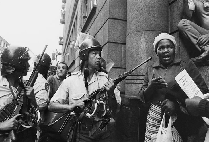 HistorySAZAR's tweet photo. Riot police attempt to block the way of workers leaving a May Day meeting at Khotso House in Johannesburg in May 1985. Khotso House was bombed by the Apartheid regime on this day in 1988. Photo Credit: Paul Weinberg/UCT https://t.co/x7YHxq7mmf