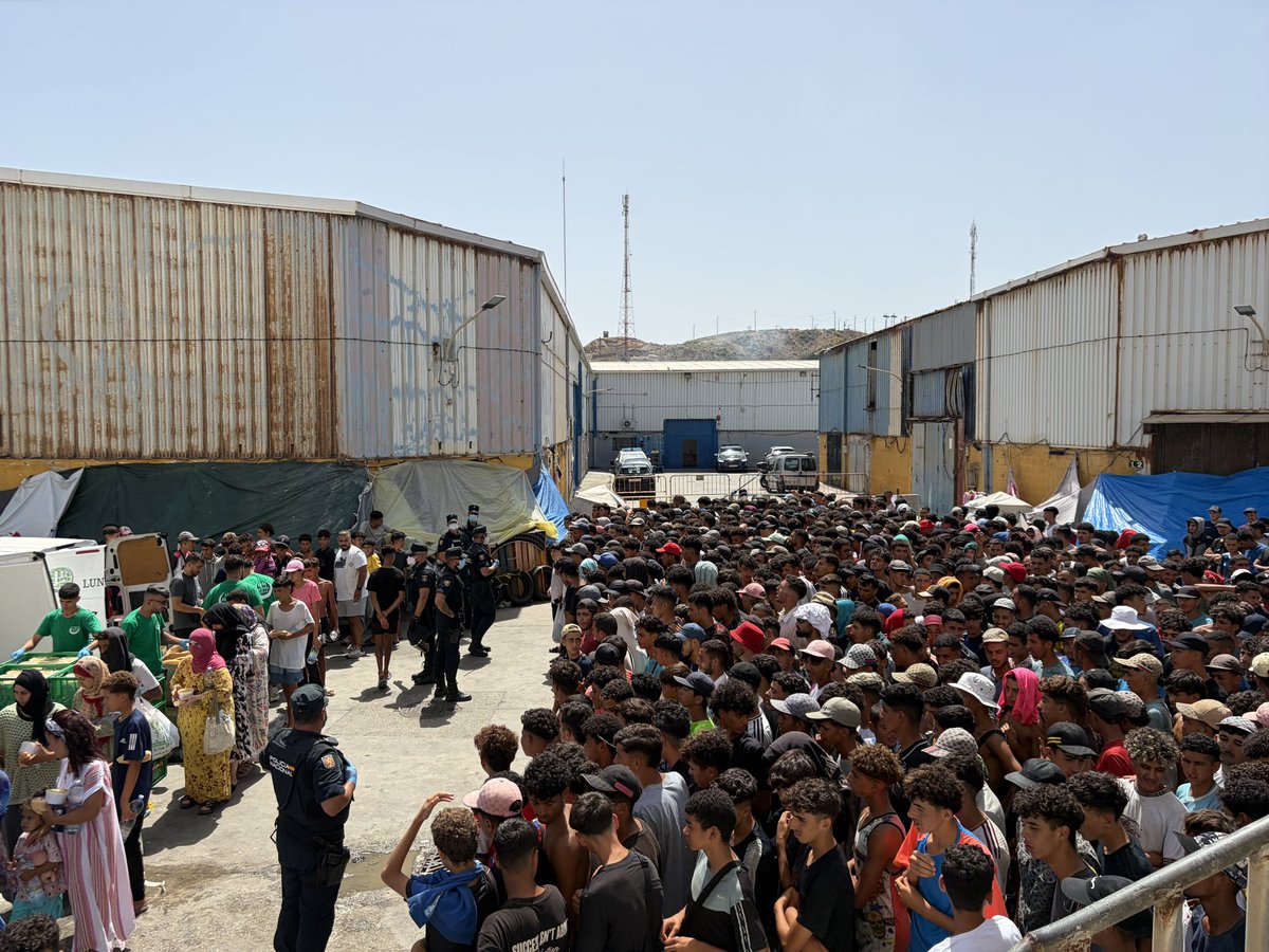 Tim_Roehn's tweet photo. Industriegebiet, #Ceuta, gerade eben: Essensausgabe durch NGO. Links: Frauen &amp; Kinder, die zuerst etwas bekommen. Rechts: der große Pulk junger Männer, die erstmal warten müssen. https://t.co/3Tlvo54DMu
