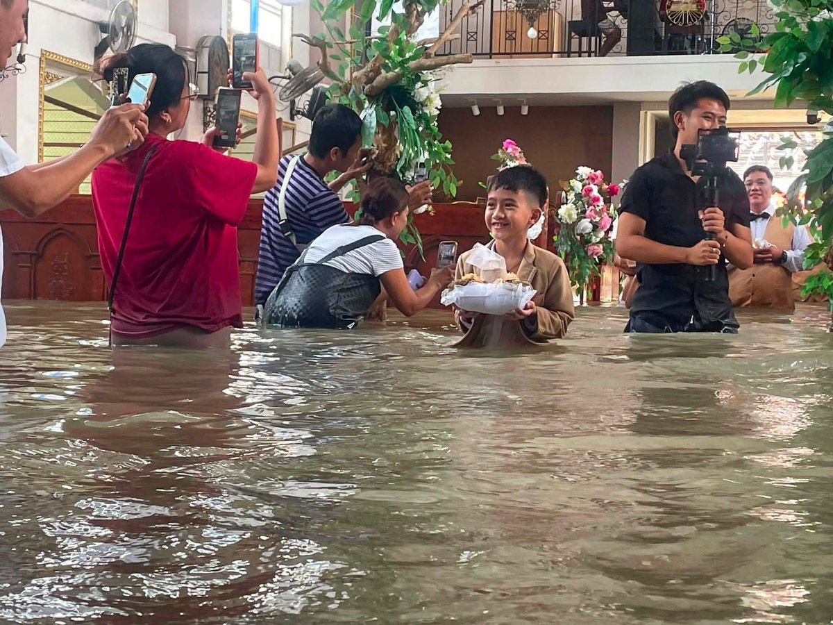 inquirerdotnet's tweet photo. TULOY ANG KASAL 💒

LOOK: A couple pushed through with their wedding ceremony in waist-deep floodwaters at San Juan Bautista Parish in Hagonoy, Bulacan, on Tuesday, September 1.

According to the parish, the couple chose not to reschedule despite flood advisories. The bride had her wedding gown shortened to navigate the flooded aisle, while the church used a portable speaker due to a power outage. | 📷: Ang Tinig - St. John the Baptist Parish Hagonoy, Bulacan via Danna Engracia, https://t.co/E0yNJSWpUY trainee