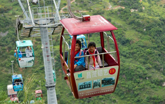 PDChinese's tweet photo. 【山裡娃坐上空中校車開學】雲南宣威尼珠河大峽谷，綿延約10公里，兩側峭壁如刀削斧鑿。新學期到來，峽谷谷底尼珠河自然村的孩子們，坐上288米的“懸崖電梯”和雲端纜車去上學。過去3個多小時的上學路，如今縮短到30分鐘。願孩子們扶搖直上，越來越好！ https://t.co/YT6wkb6Kfr