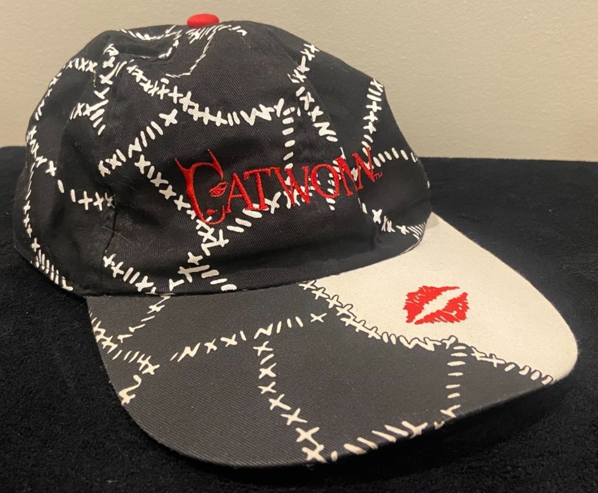BatmanAnthology's tweet photo. Photos of a Batman Returns Catwoman Hat, which features the iconic stitches on her cat suit, the alternate character logo, and a kiss mark on the brim. This is such an amazing hat honestly, I kinda need it. https://t.co/Z3fMA34NPQ